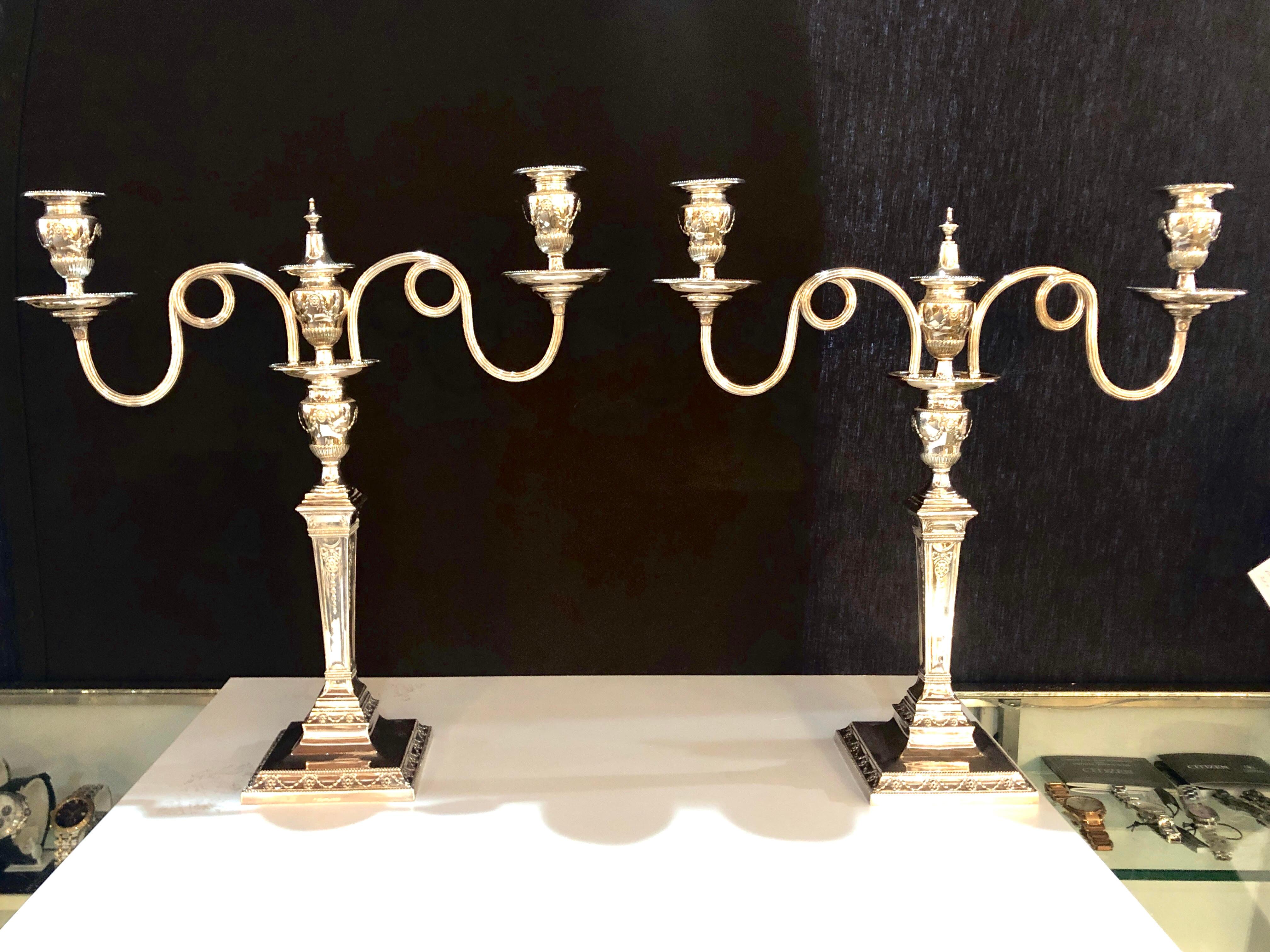 A fine early pair of silver plated Sheffield three-arm hallmarked candelabra each having a detachable group of branches. These finely chased pair of candelabra are simply stunning and ready to sit upon any table setting.