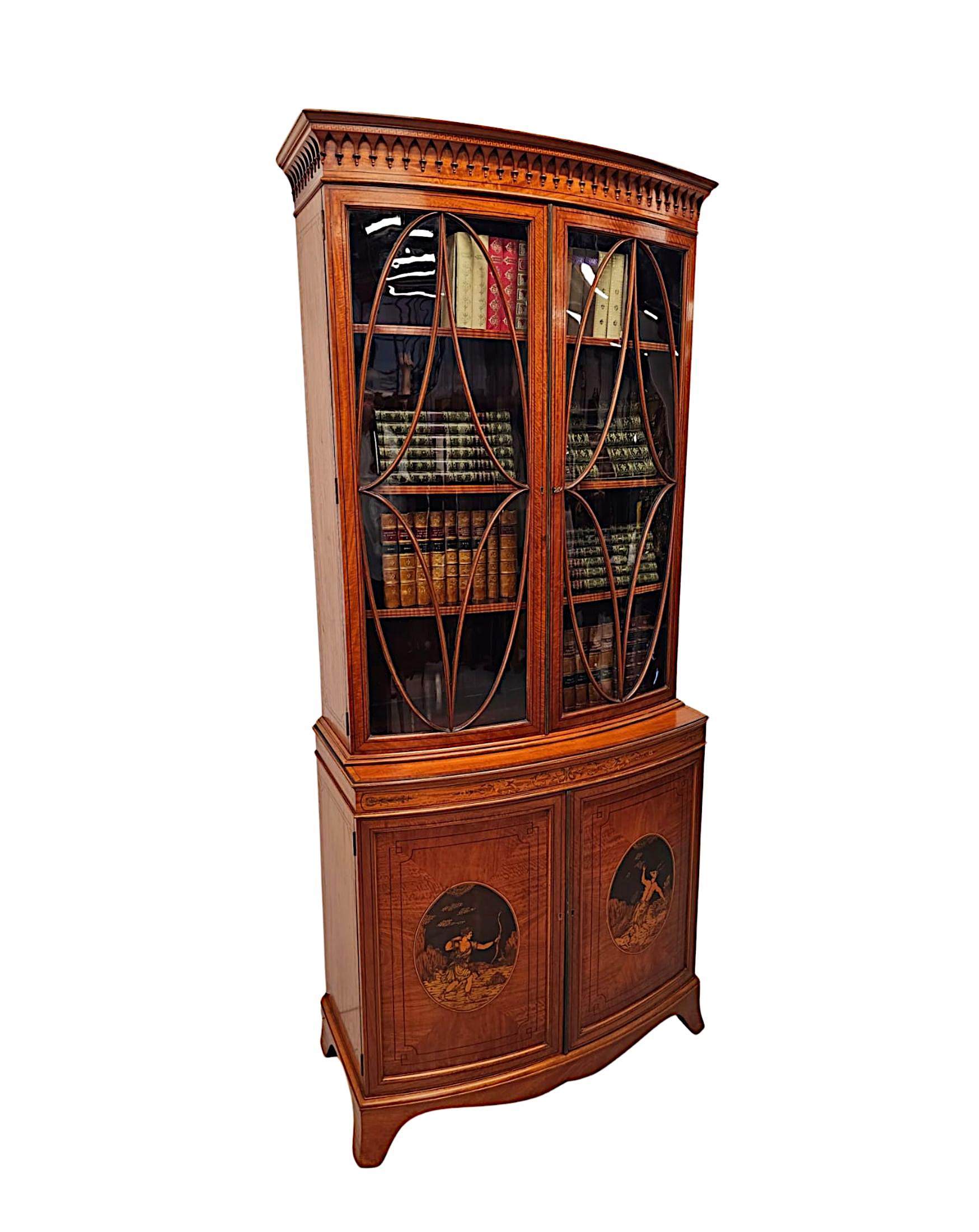A very fine Edwardian well figured satinwood bowfronted bookcase in the manner of Edward and Roberts, London, of exceptional quality, line inlaid, fabulously carved with gorgeously rich patination, grain and with stunning marquetry detail of