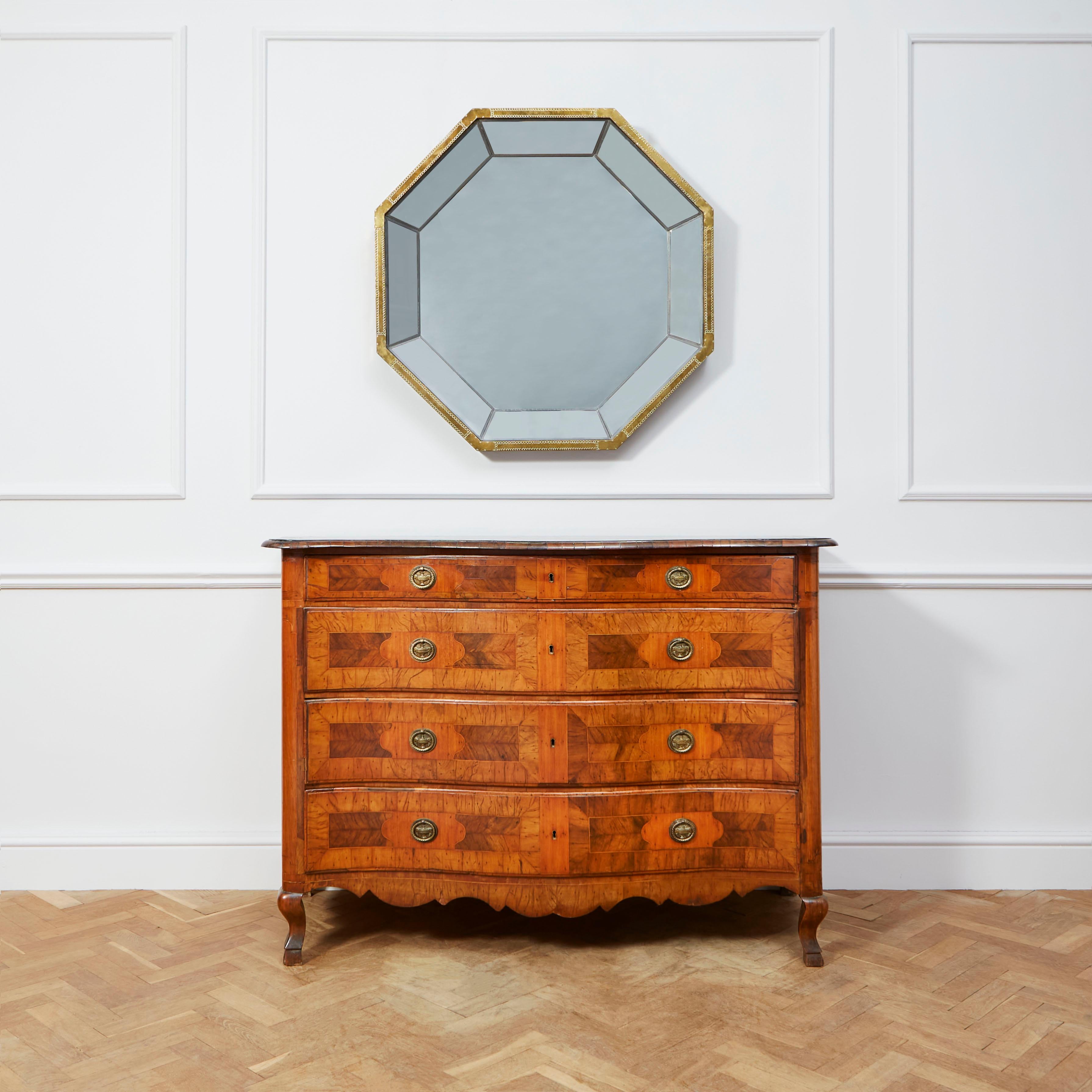 A fine fruitwood serpentine commode, the shaped top with cross banded veneers and two central lozenge motifs in limewood, above four long graduated drawers, the fronts decorated with panels of lime, olive and walnut and with original steel locks to