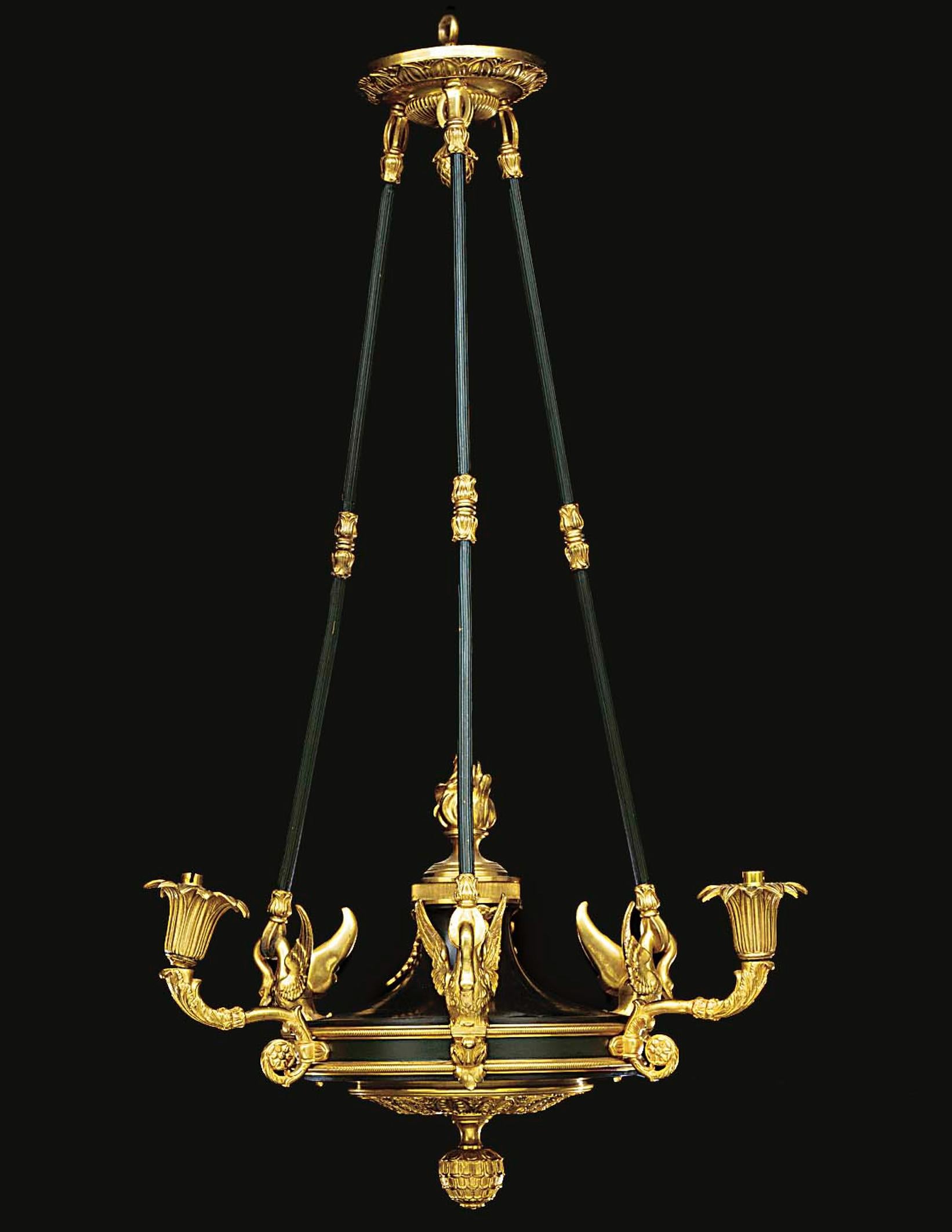 A fine Empire style gilt and patinated bronze three-light chandelier, with a circular corona cast with stiff leaves and a pine cone boss above reeded suspension rods with swan terminals and a flame finial.

French, circa 1900.