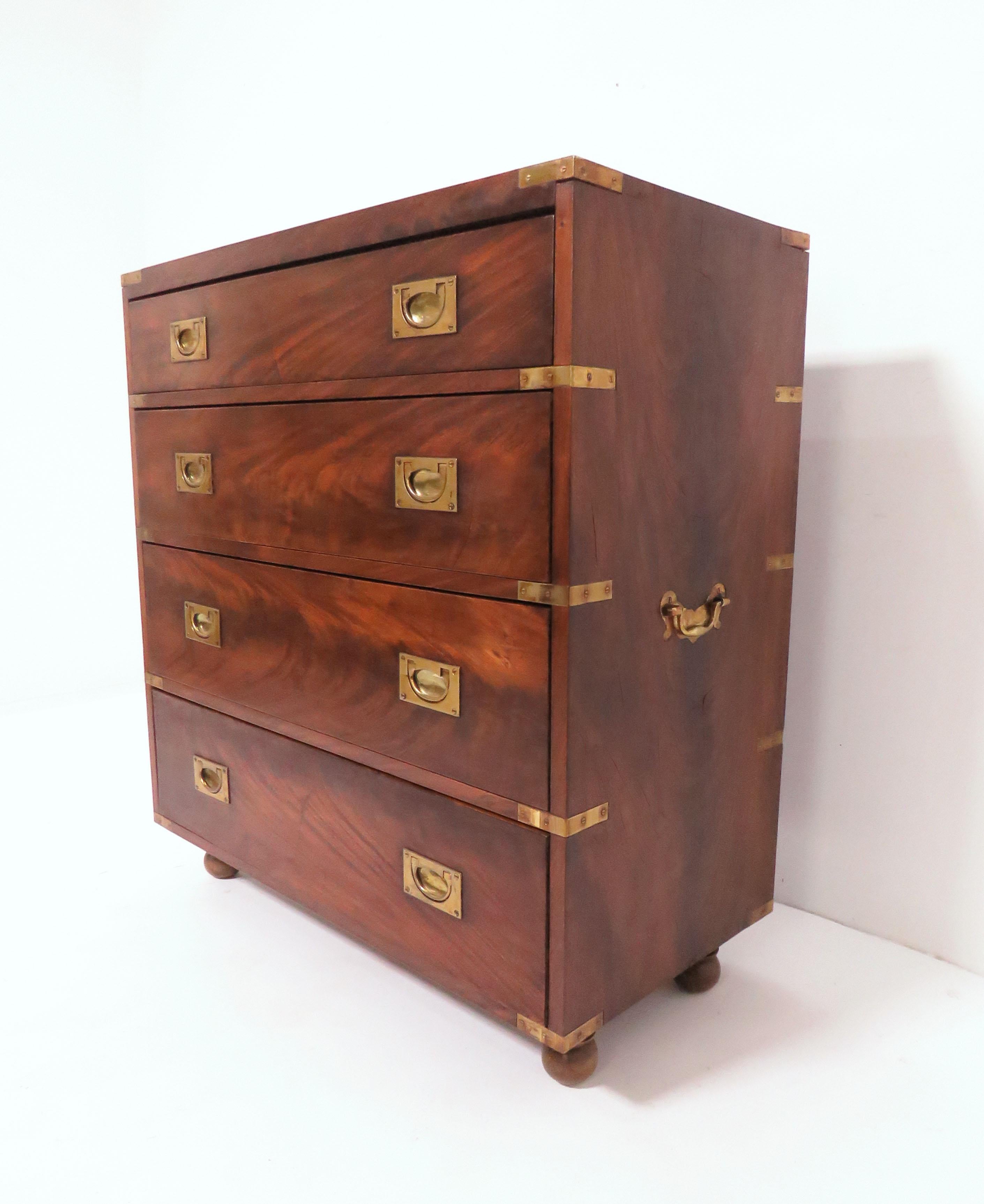 A very fine four drawer campaign dressing chest in flamed mahogany with solid brass hardware on ball feet.