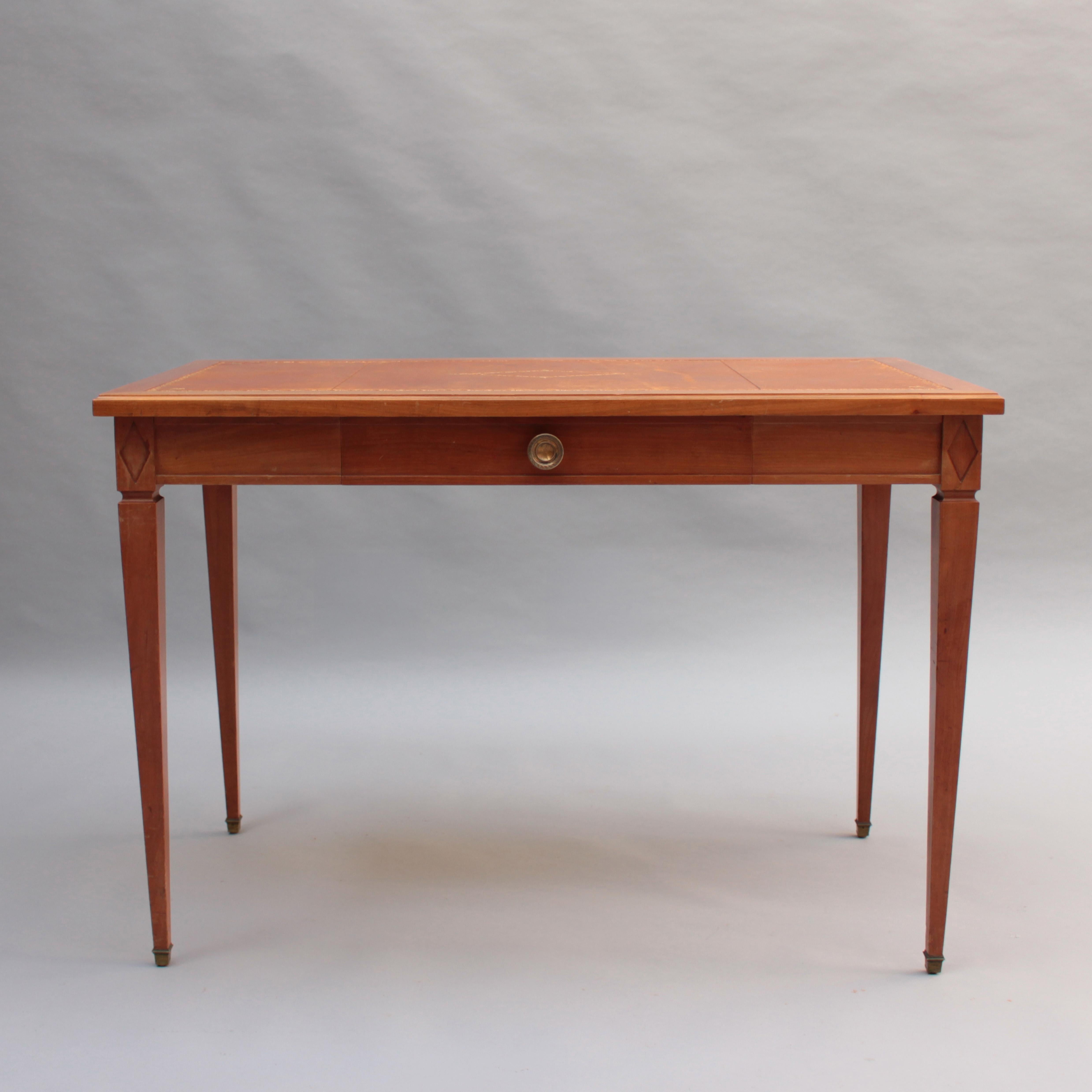 Un raffinato tavolo da scrittura neoclassico francese in ciliegio in stile Luigi XVI con un cassetto, tiretto e sabot in bronzo e piano in pelle.