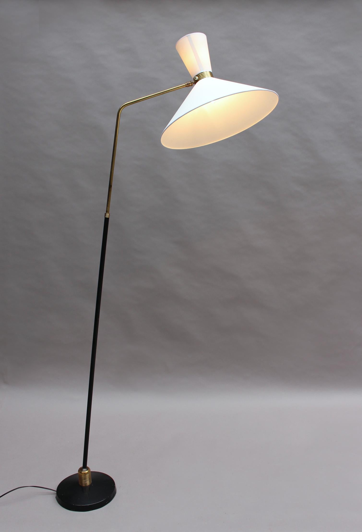 Made of black lacquered metal and brass, with a (new) articulate diabolo shade and adjustable stem. By Maison Lunel.