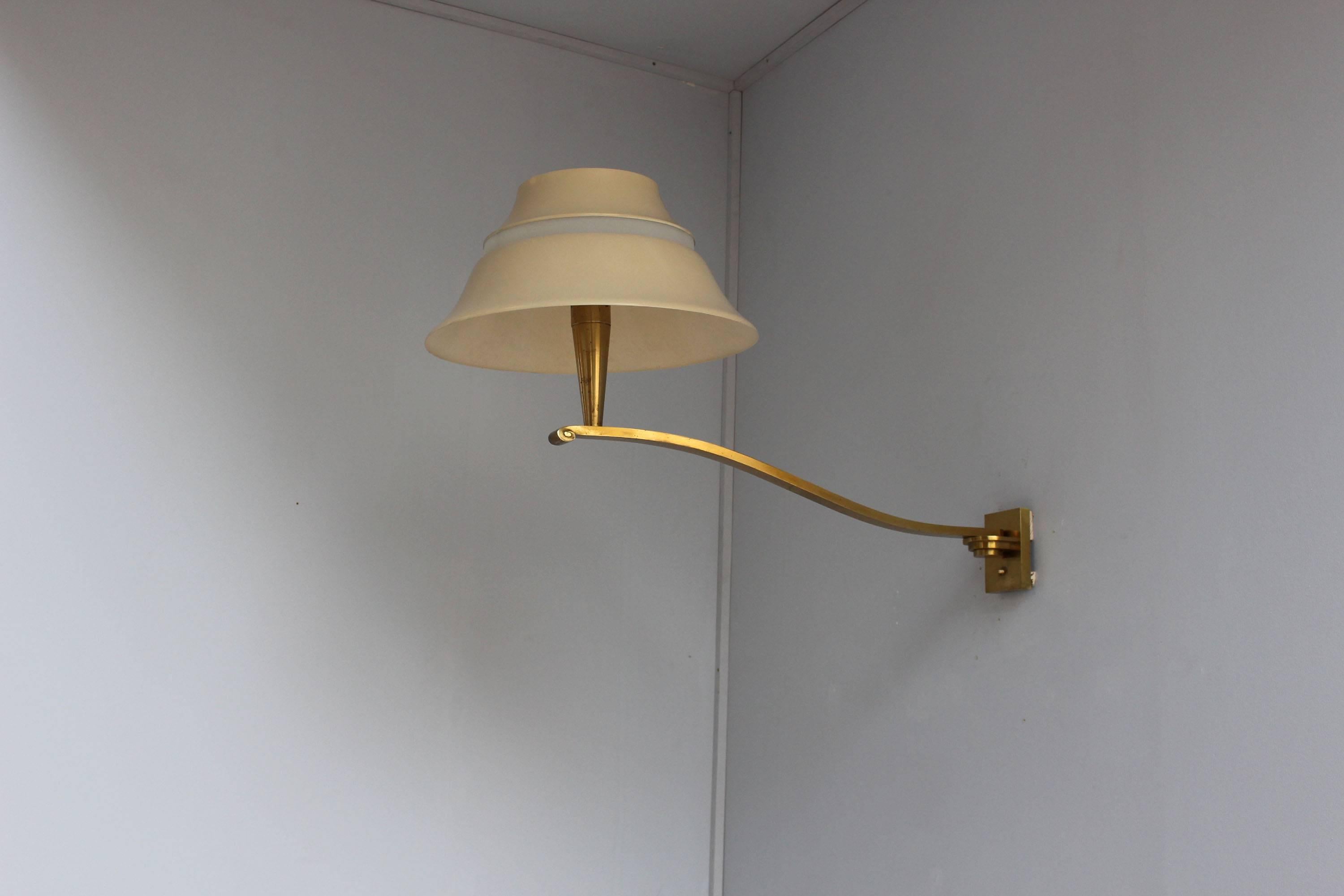 Rare and elegant French mid-century wall light by Jean Perzel, made with a pivoting bronze arm that supports a lacquered metal and enameled glass shade.