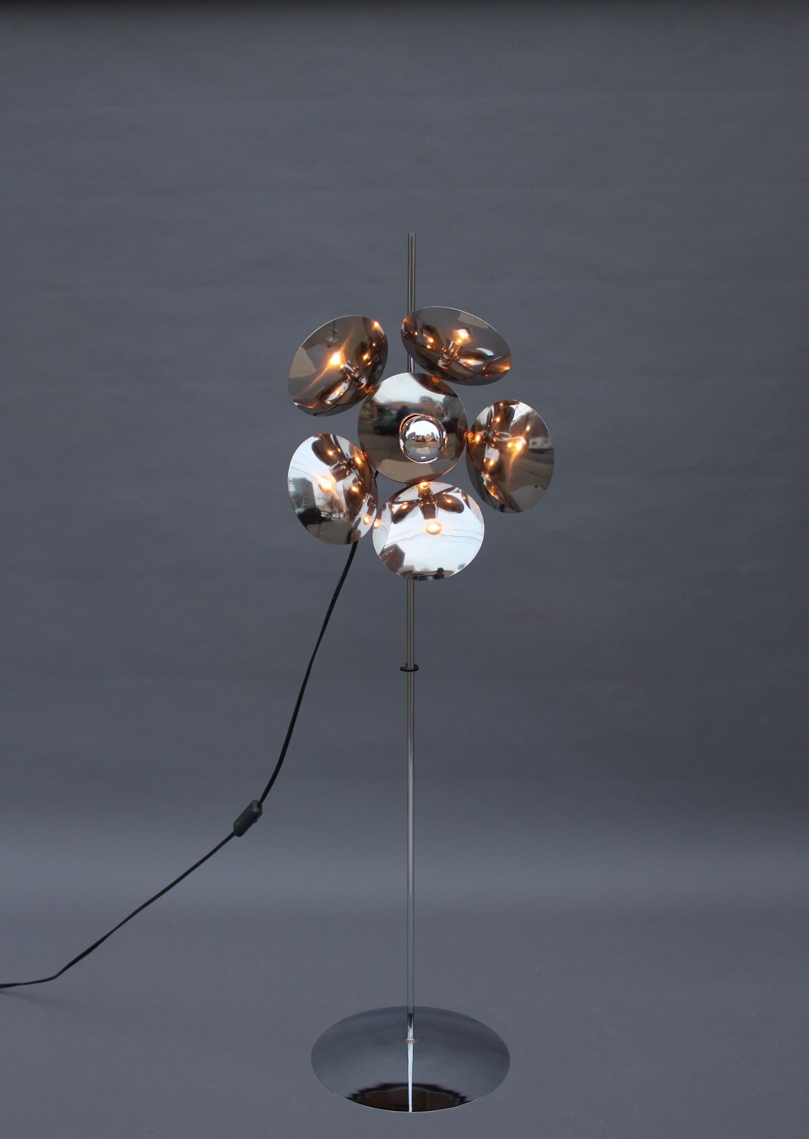 With a adjustable flower shape shade attached to a minimalist rod and base. 
Minimal height is 47.75 in (top of the rod).
