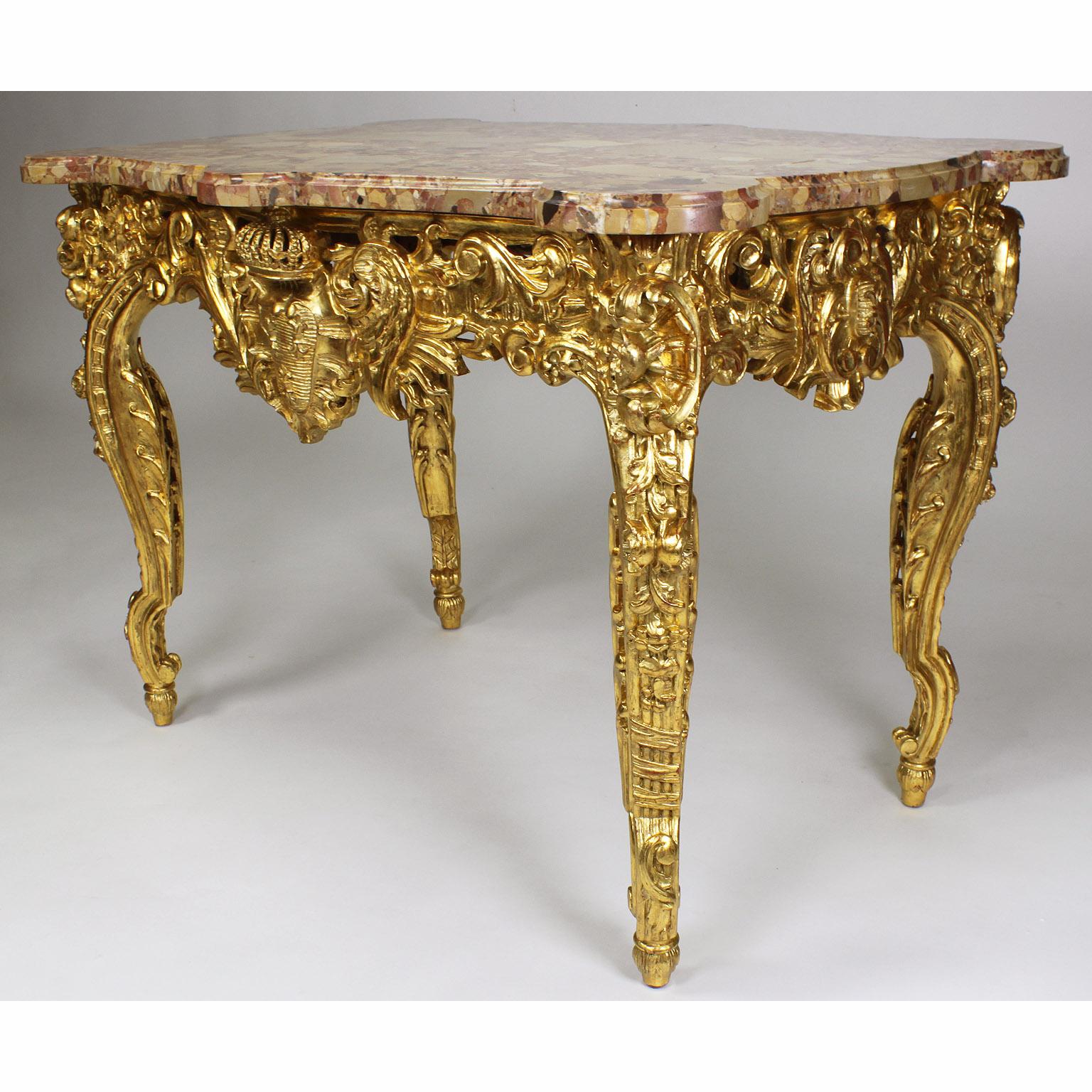 Ein sehr schöner französischer Tisch im Stil Louis XV, geschnitzt aus vergoldetem Holz, mit einer Platte aus Brêche d'Alep-Marmor. Die serpentinenförmigen Vorder-, Rück- und Seitenschürzen dieses fein geschnitzten Tisches sind mit einem königlichen