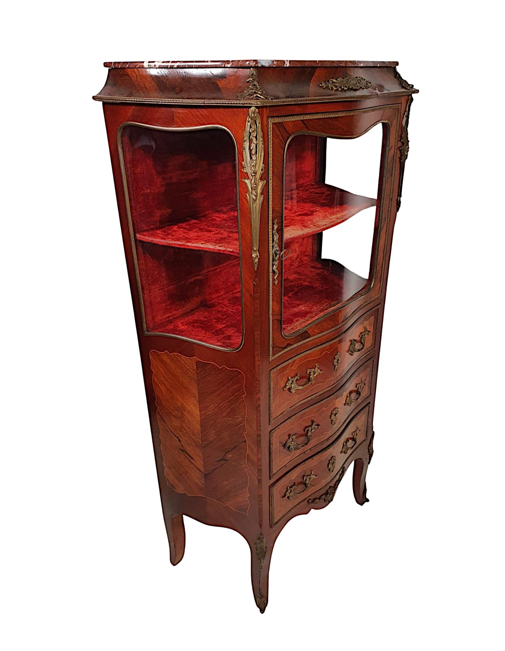 A fine French 19th century serpentine inlaid display or storage cabinet of neat proportions, cross banded and ormolu mounted throughout and with lovely patinated timbers comprising of kingwood and fruitwood. The shaped Rosso Levante marble top