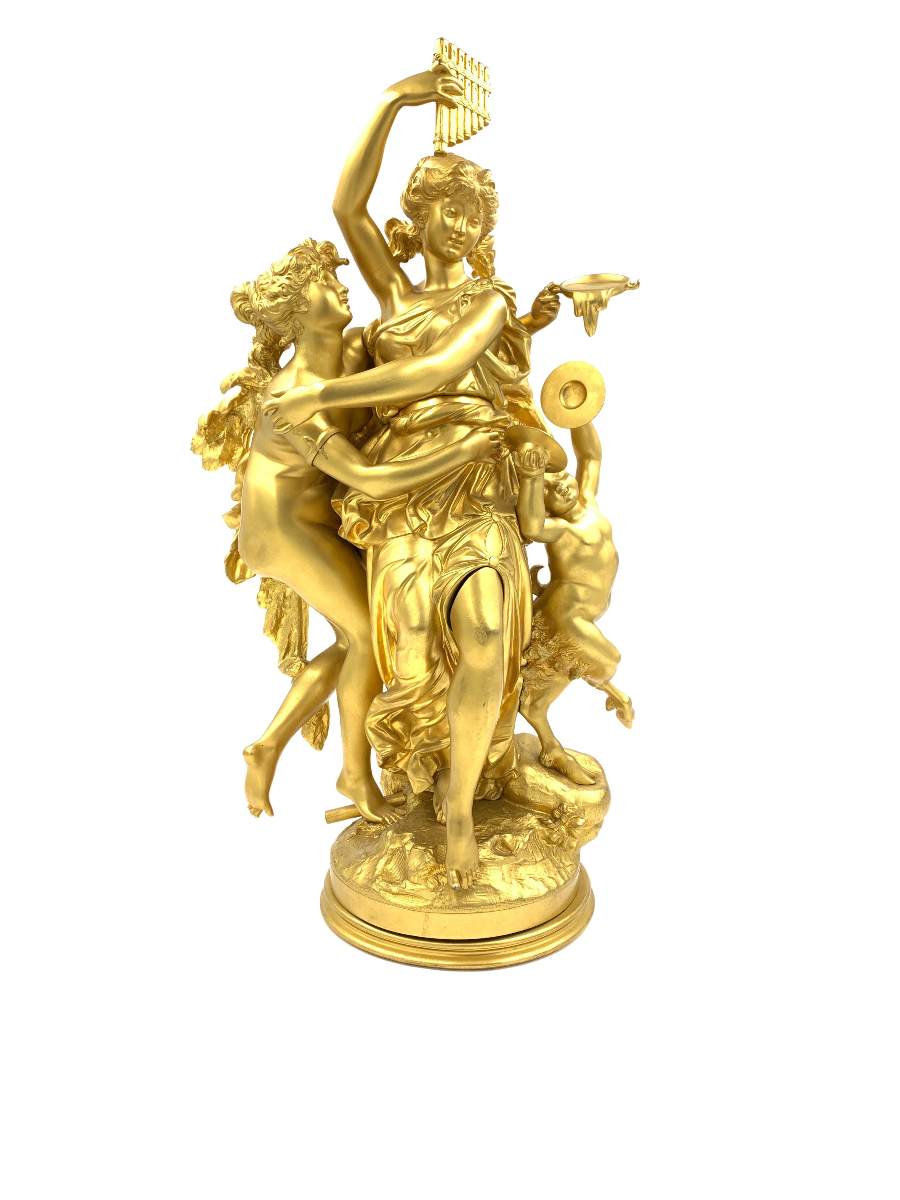 A French gilt bronze Bacchic figural group, late 19th century, with two dancing nymphs and a satyr, with impressed mark for Jules Graux Foundry to the socle, presented on a later fluted variegated grey and white marble column. 

Measures: H: