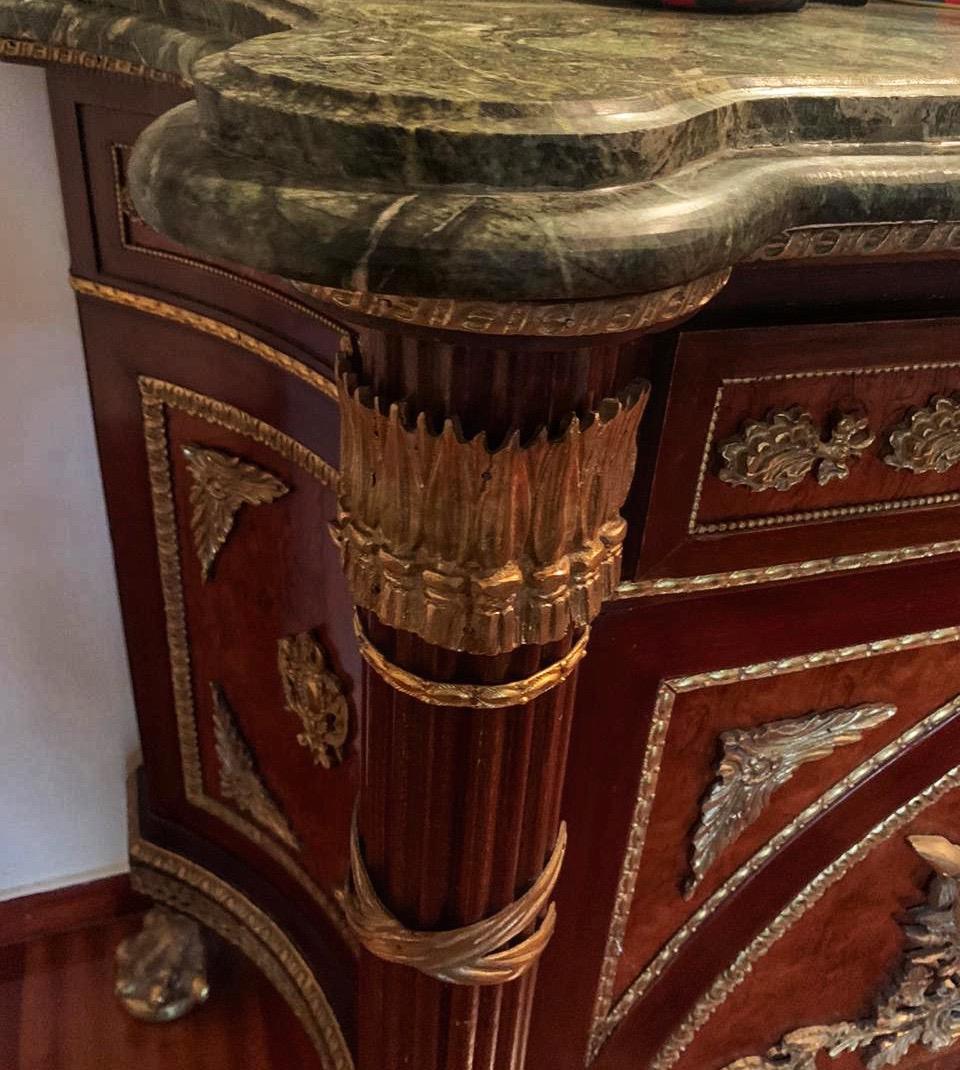 French ormolu-mounted commode a Vantaux after Guillaume Benneman, late 19th century
Trapezoid form with a thick green marble top above a paneled frieze with trailing oak leaf mount, above a pair of elliptically paneled doors heavily mounted with