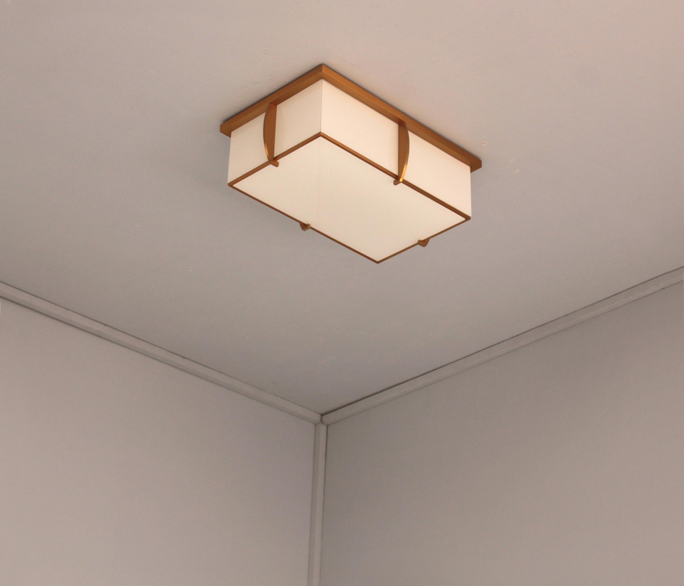 Mounted on a gold lacquered bronze frame that holds the white laminated glass diffusers. The flat bottom glass diffuser is removable in order to change the bulbs.
Signed