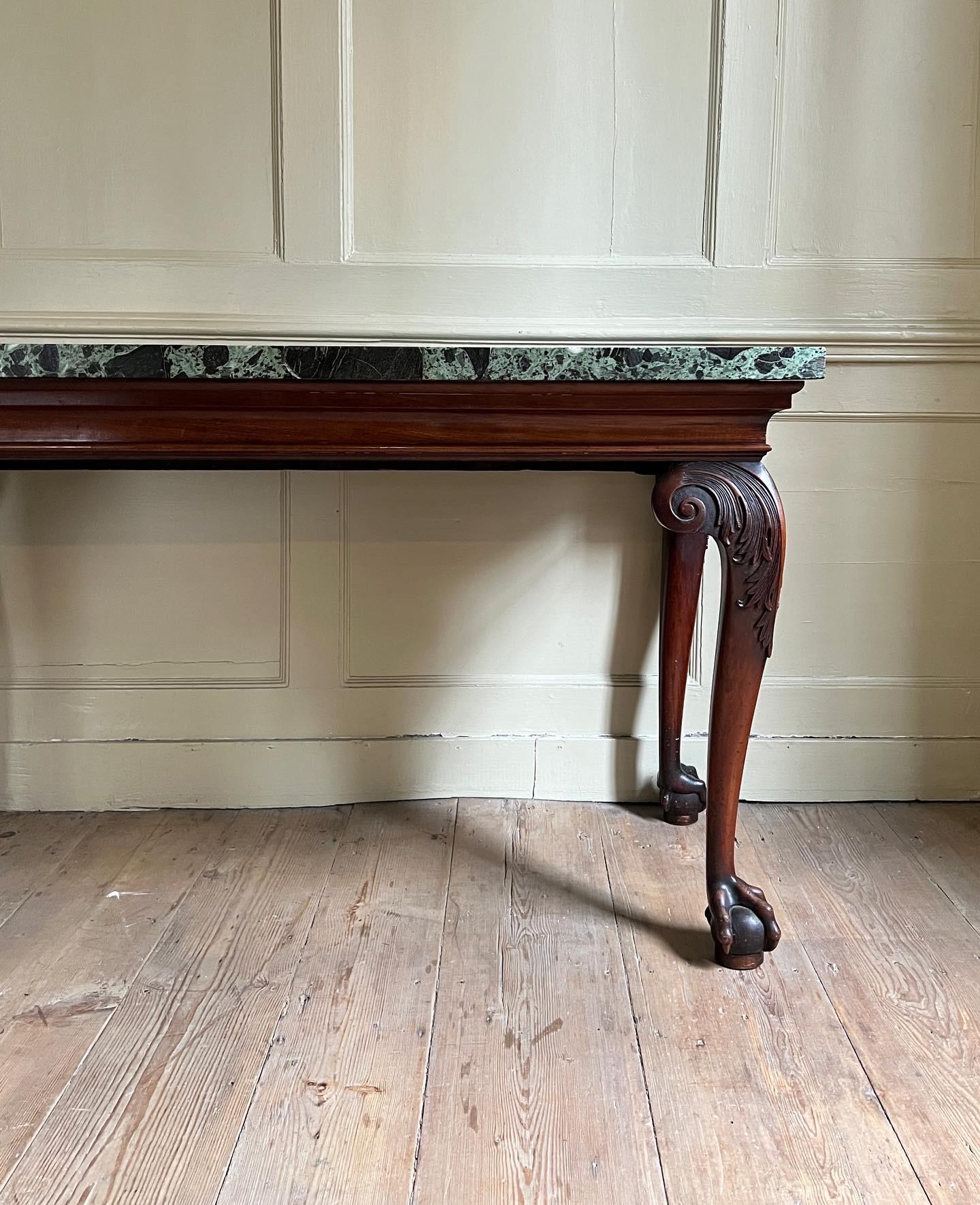 A fine George II period serving table of architectural design and strong proportions. English, c.1740. The four cabriole legs are finely carved with acanthus to the knees and are raised on bold ball & claw feet. The cavetto moulded frieze supports a