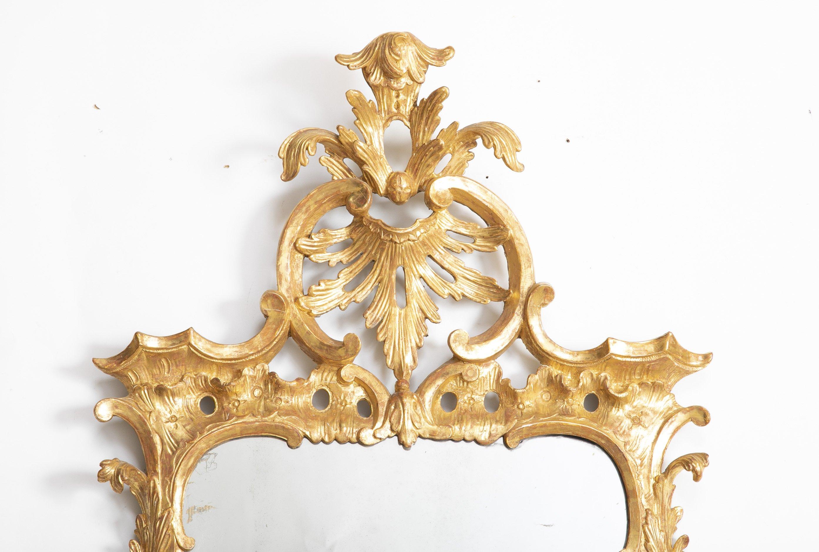 English George III gilded and carved Rococo mirror with carved shell crest, openwork, floral and leaf carved sides and original plate, circa 1750s.