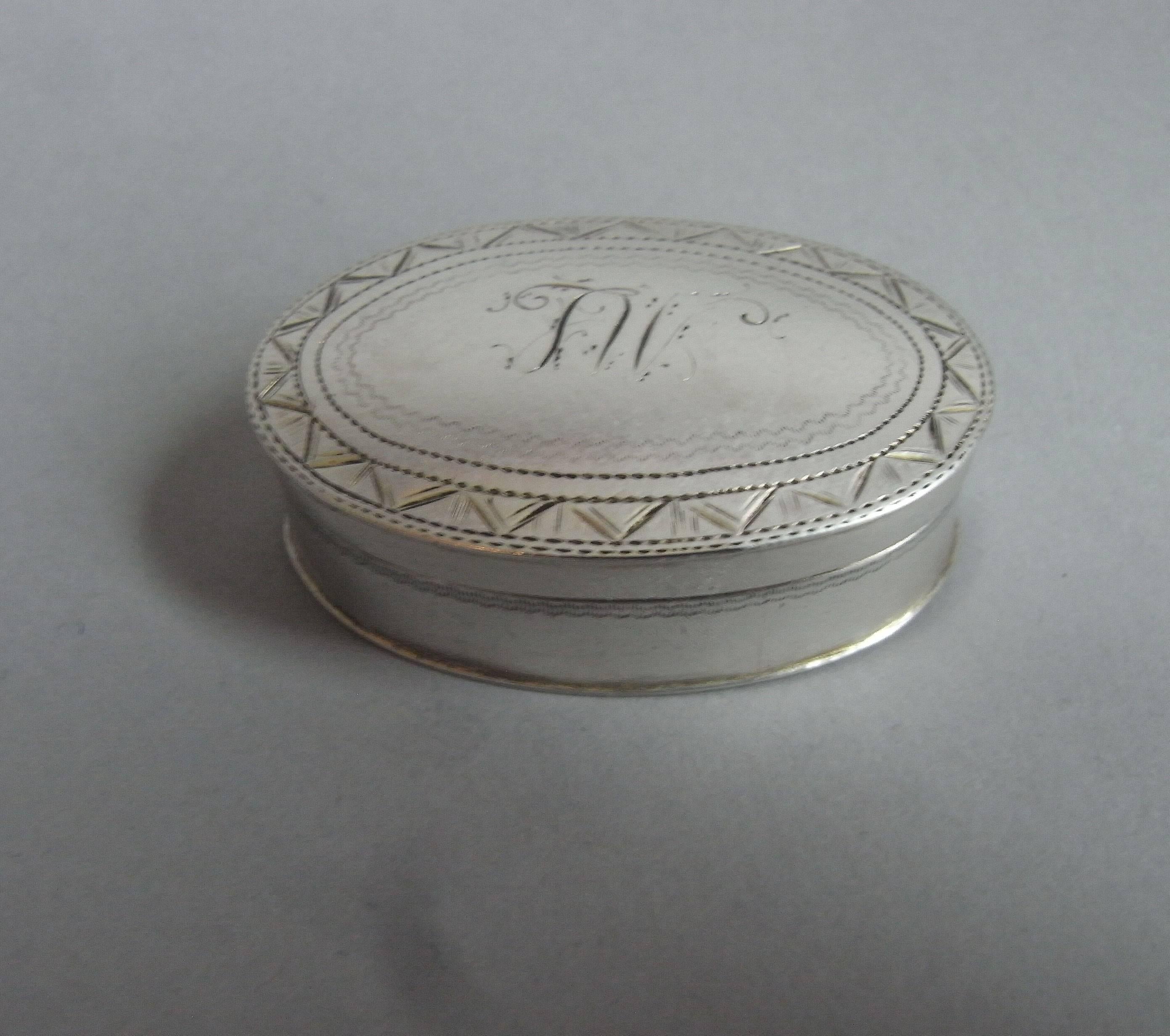 The patch box is of an unusually large oval form, with a pull off cover. The cover is decorated with an outer prick dot and arrow head border, around a set of contemporary script initials. The base is engraved with prick dot bands. The box has a