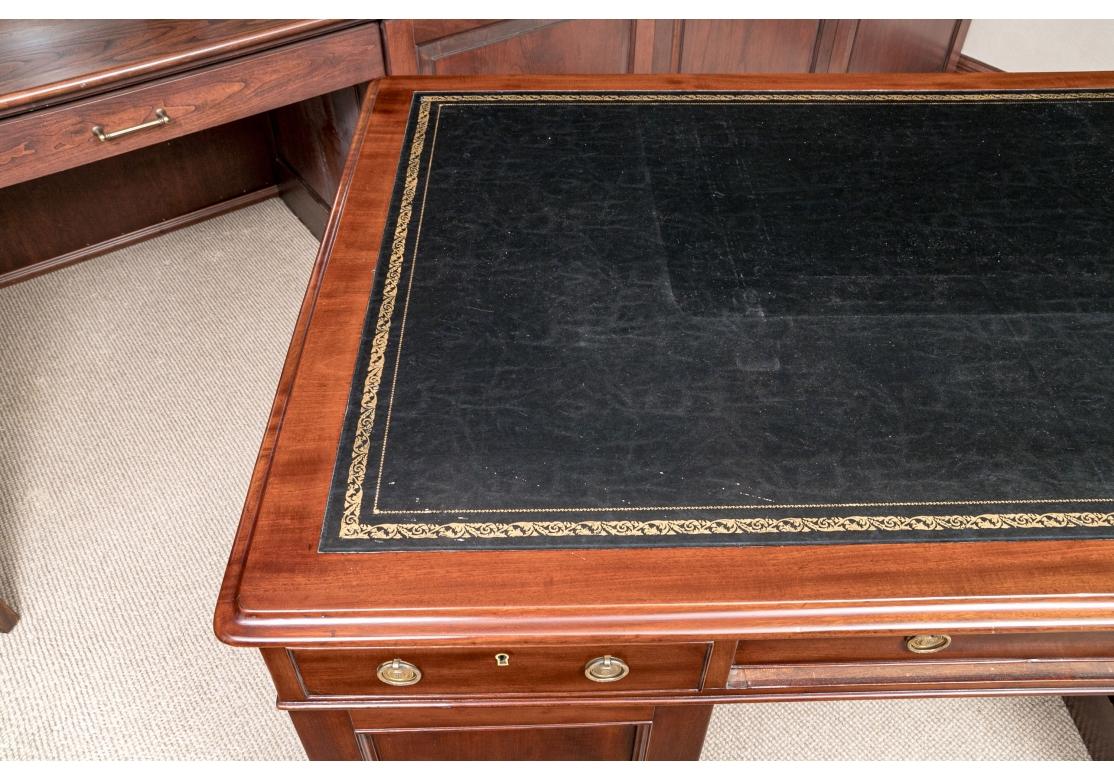 A massive partners desk having a black leather tooled inlay and gilt embellishments. The whole having twelve drawers and brass pulls in three parts.
Lacking a key. 

Dimensions: 60