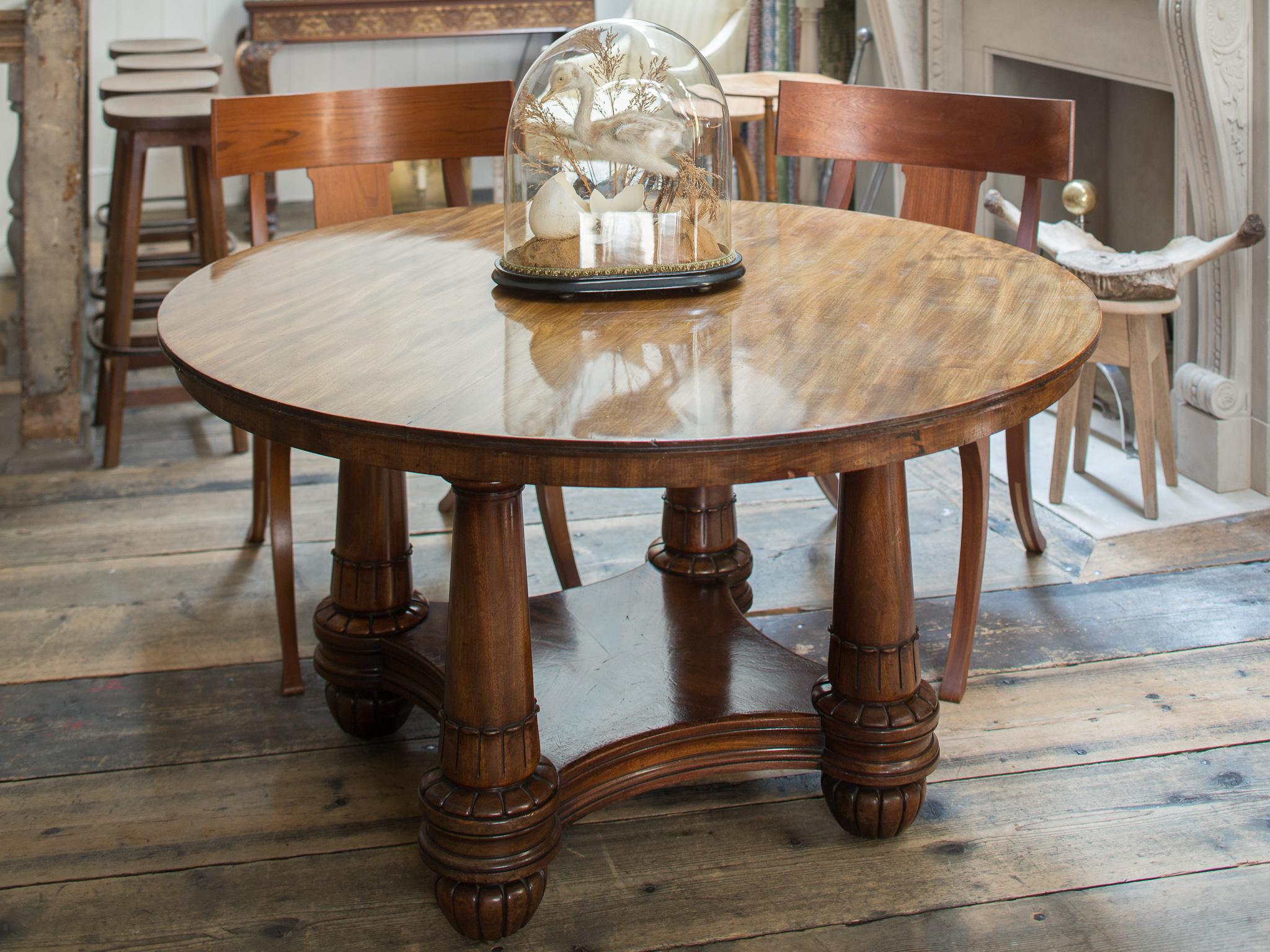 A Fine George IV Mahogany Extending Table

In the manner of Robert Jupe. The circular moulded top with additional concentric outer leaves above four tapering columns united by an undertier on carved and flattened bun feet

Height 73 cm, 28