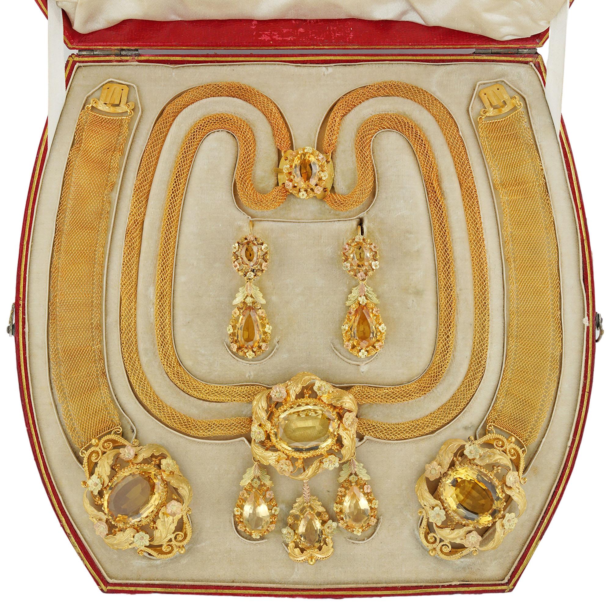A fine Georgian citrine and gold parure, consisting of a necklace, a pair of earrings and a pair of bracelets, the necklace consisting of an oval-cut faceted citrine surrounded by a gold frame of foliate design, suspending three detachable drop-like