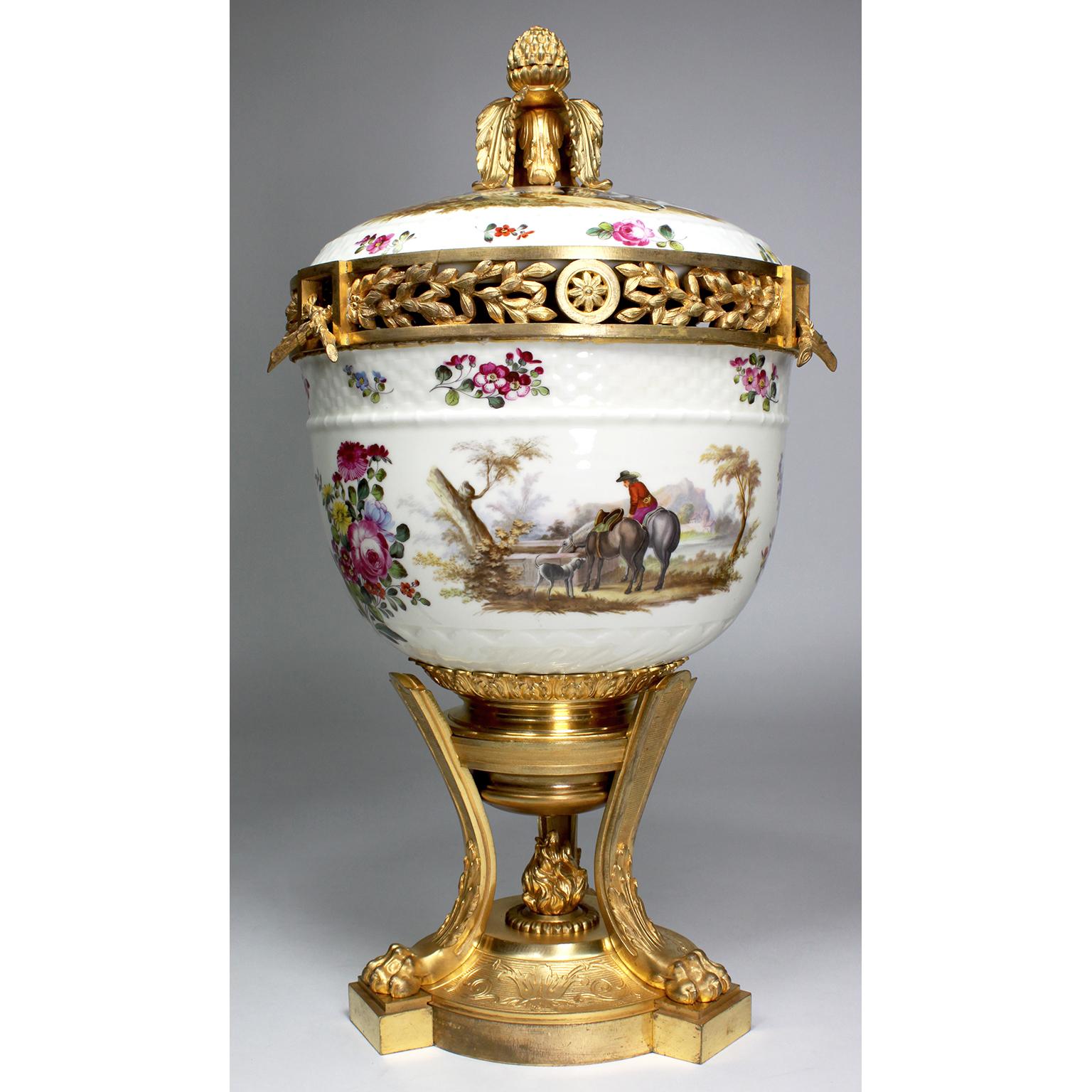 Très beau vase-urne à pot-pourri en porcelaine et bronze doré avec couvercle, attribué à Meissen. L'urne ovoïde en porcelaine blanche, décorée sur tous les côtés et sur le couvercle de scènes de chasse en plein air, avec des paysans, des chevaux,