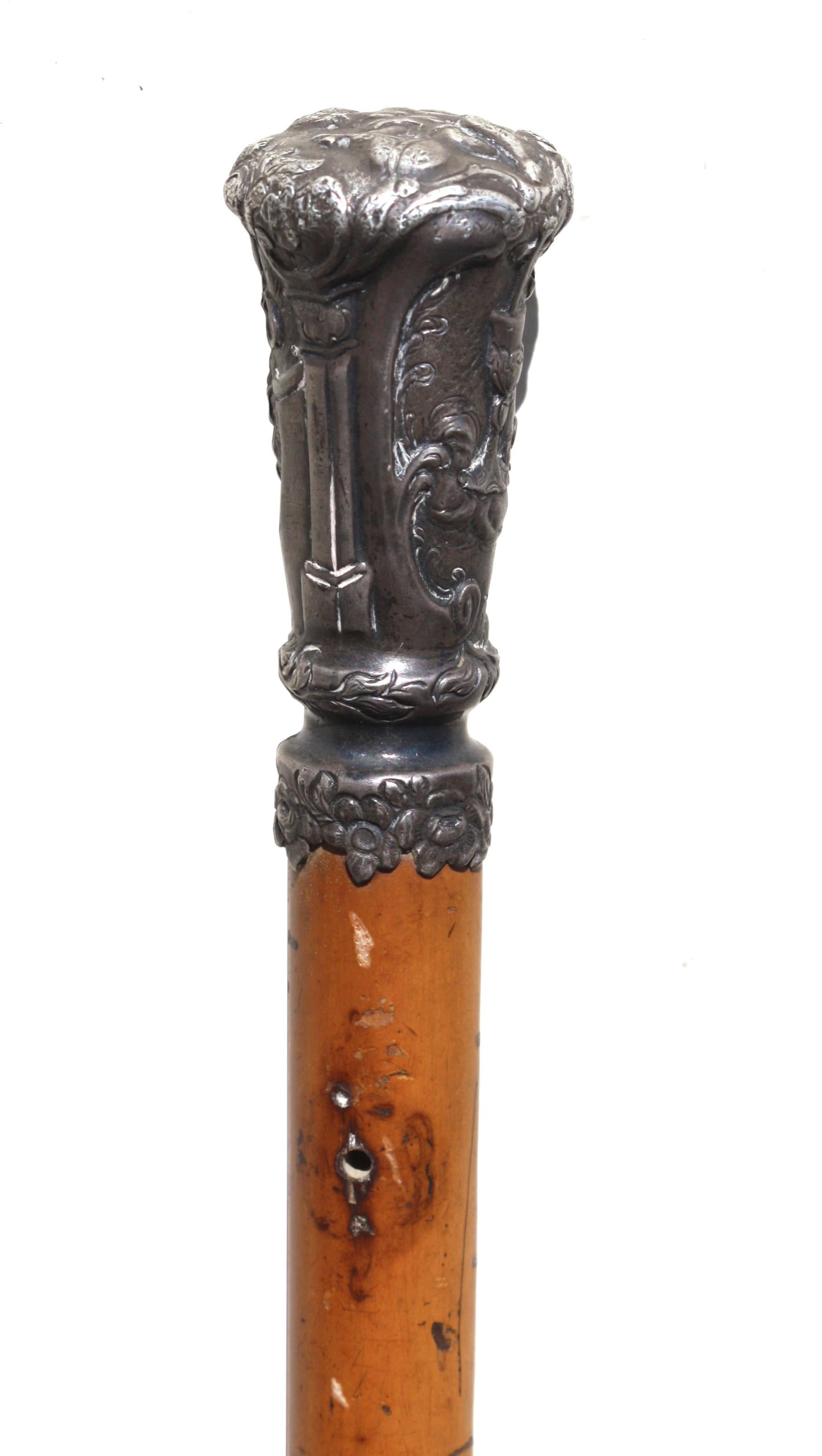 A fine German Silver and Malacca Gentleman's walking stick, 
circa 1770-1790 
the handle elaborately chased with a child holding an orb, an anchor, a heart and a goblet, the tapering malacca shaft ending in a 4 1/4 metal ferrule, 
the handle is