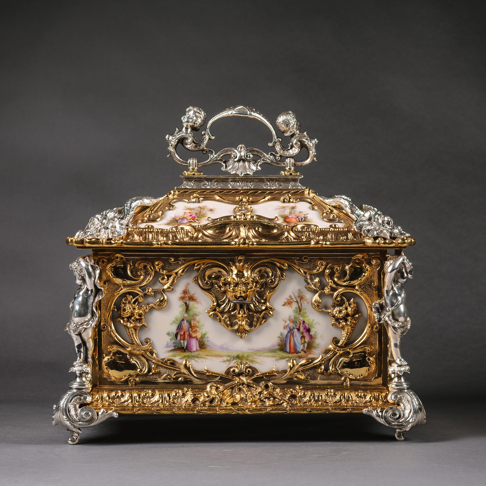 A Fine Gilt and Silvered Bronze Porcelain Inset Casket.

This casket of large proportions has gilt and silvered bronze sculptural mounts. The porcelain panels to the sides and to the top are finely painted with courting couples in eighteenth century