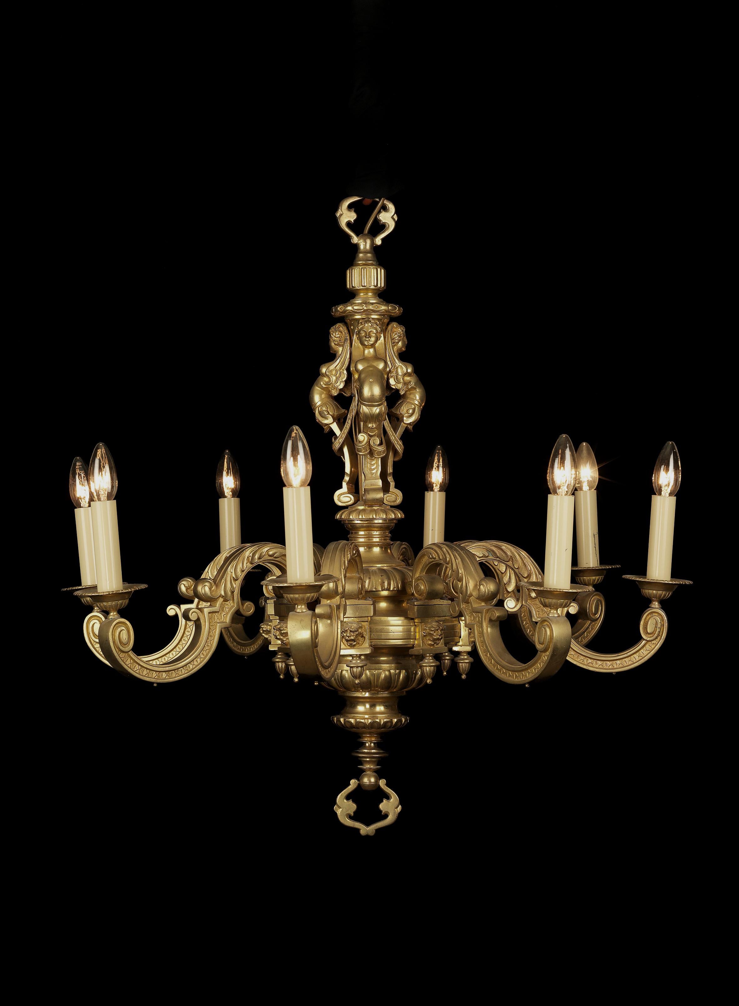 A fine gilt-bronze Louis XIV style eight-light chandelier.

A fine gilt-bronze Louis XIV style eight-light chandelier with acanthus cast candle arms. Each arm is depicted with a grotesque mask and the stem finely cast with three winged