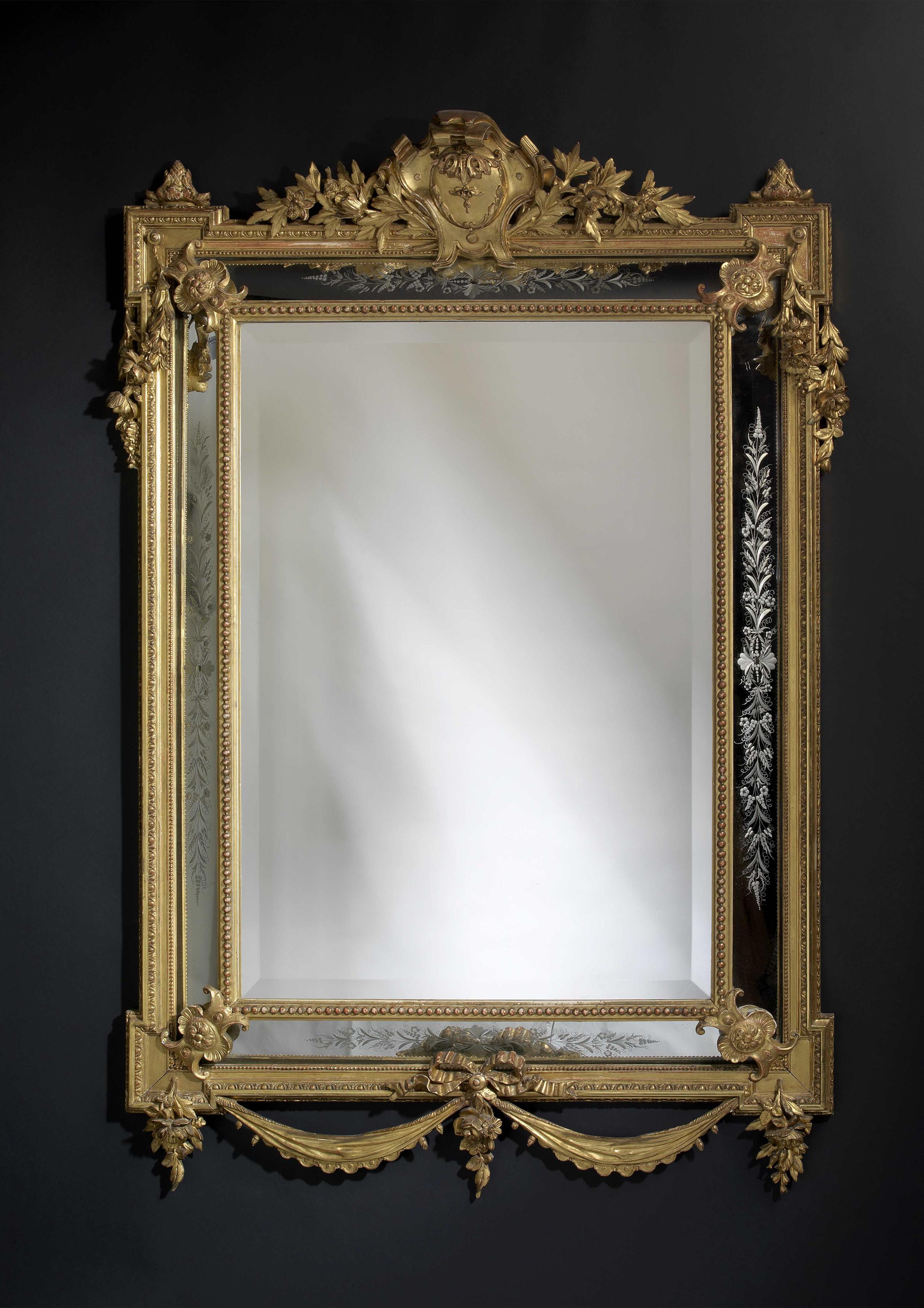 A fine giltwood cushion mirror with etched side plates. 

French, circa 1880. 

The rectangular mirror plate is framed by marginal etched side plates within a beaded and egg and dart carved rectangular giltwood frame with out-set corners and