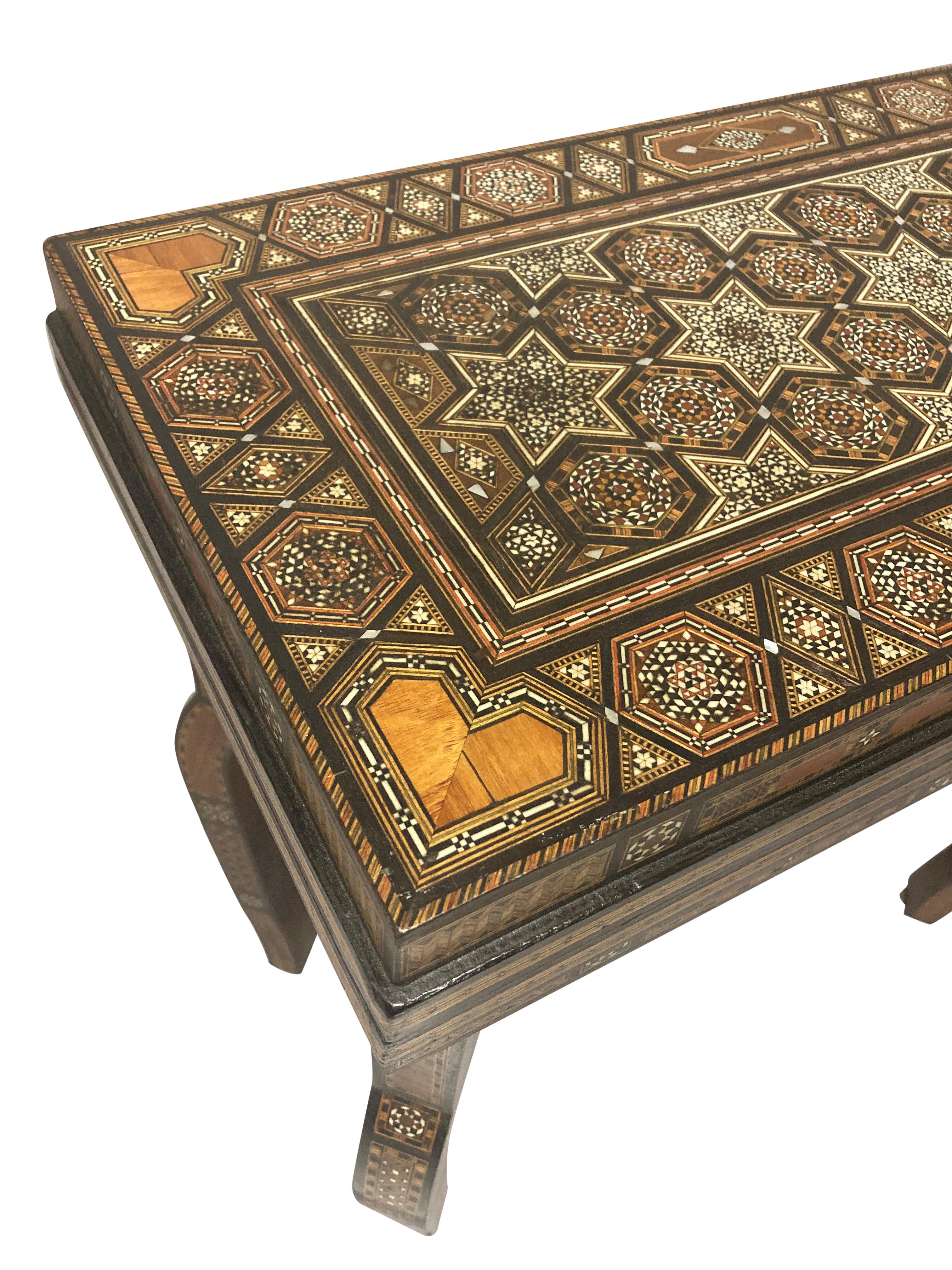 A Moorish games table of on cabriole legs, with a folding top, opening to reveal various games layouts, including a card table. Comprised mainly of olive wood, with hardwood and bone micro-mosaic inlay. Beautifully restored.