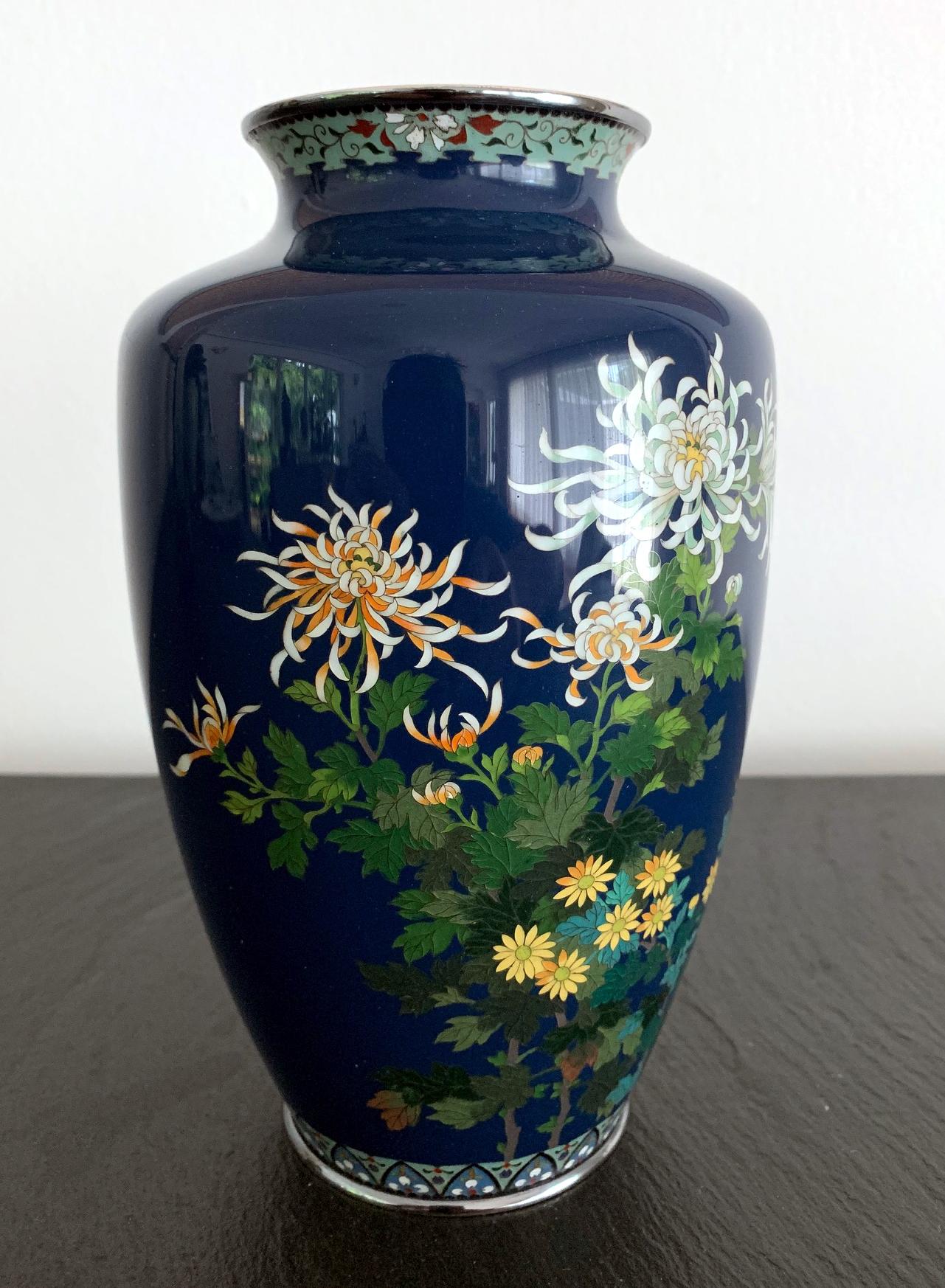 A Japanese cloisonne vase of fine quality by the workshop of Hayashi Kodenji (1831-1915) dated to early 20th century 1910s-1930s. In a mid-night dark blue background that the artist was known for, an arrangement of a variety of chrysanthemum flowers