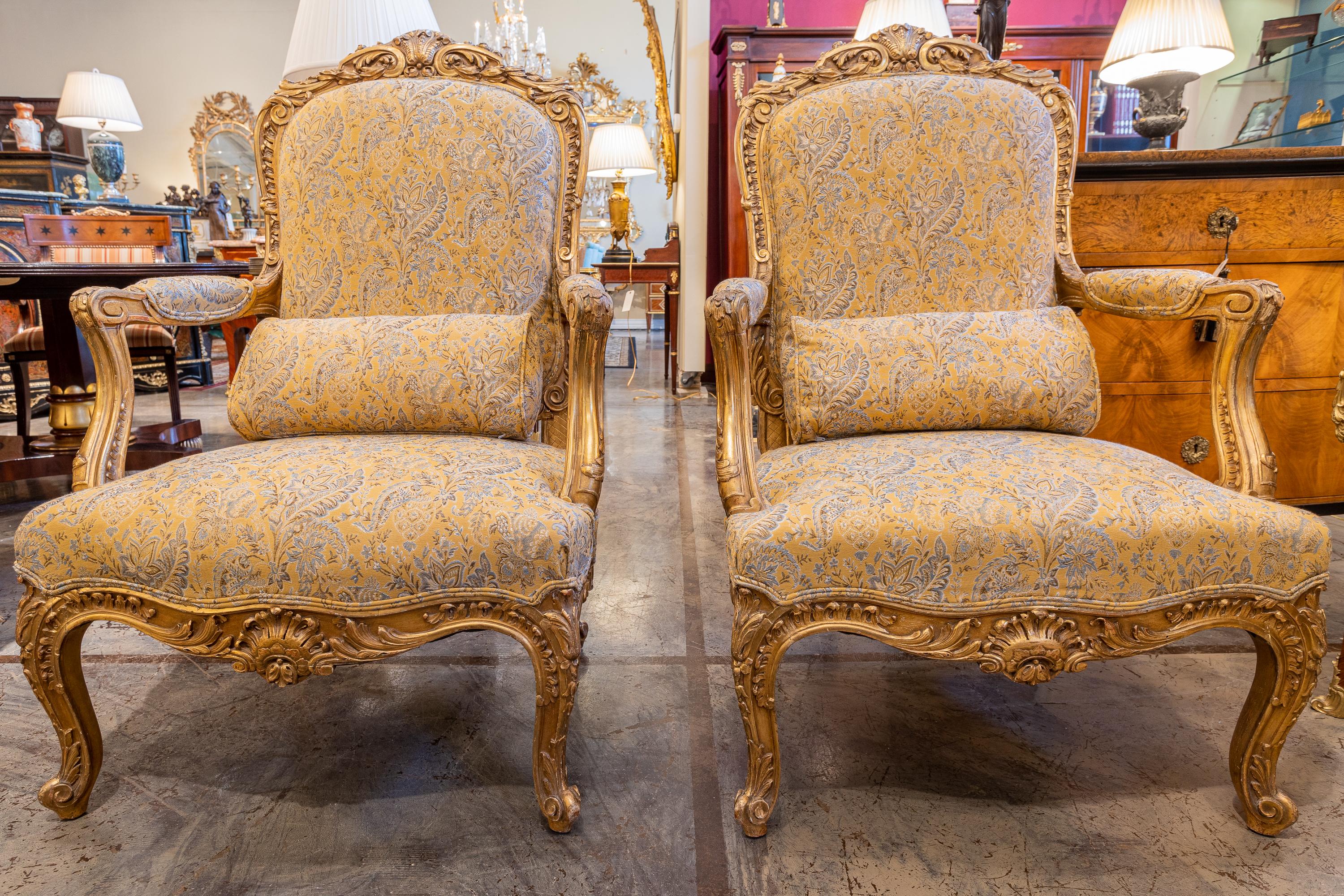 A fine large pair of French 19th century Louis XV gilt carved open armchairs. Covered in a French material