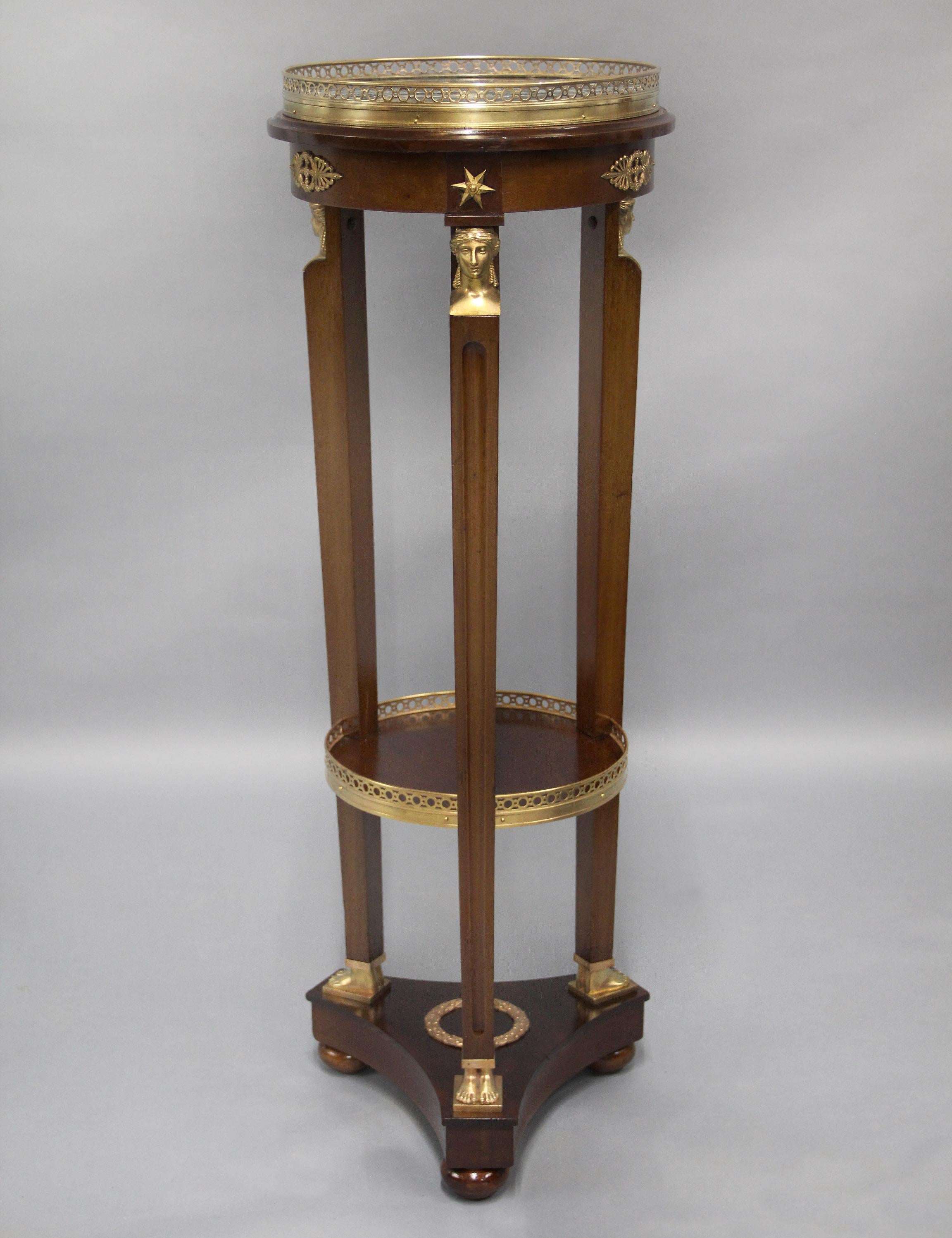 A Fine Late 19th Century Gilt Bronze Mounted Empire Style Two Tier Pedestal

The Vert marble with a reticulated bronze gallery top leading to a tripod of legs headed by Egyptian bronze bust of maidens, leading down to a similar shaped galleried