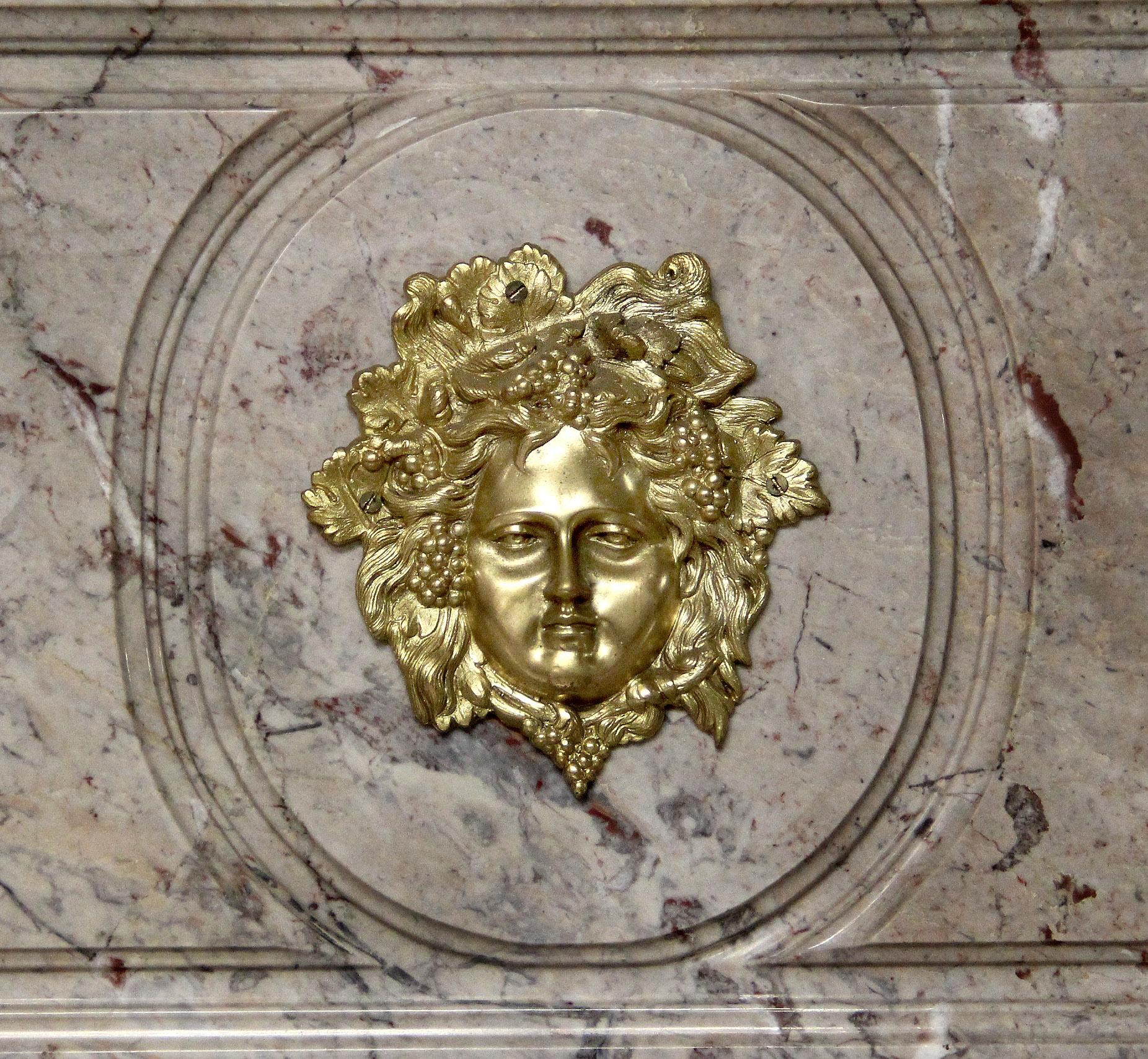 A large and fine late 19th century Louis XVI style gilt bronze mounted marble top console / server

A marble top and backsplash centered with a gilt bronze mask, above two center drawers, the bottom with a wood backsplash standing on two