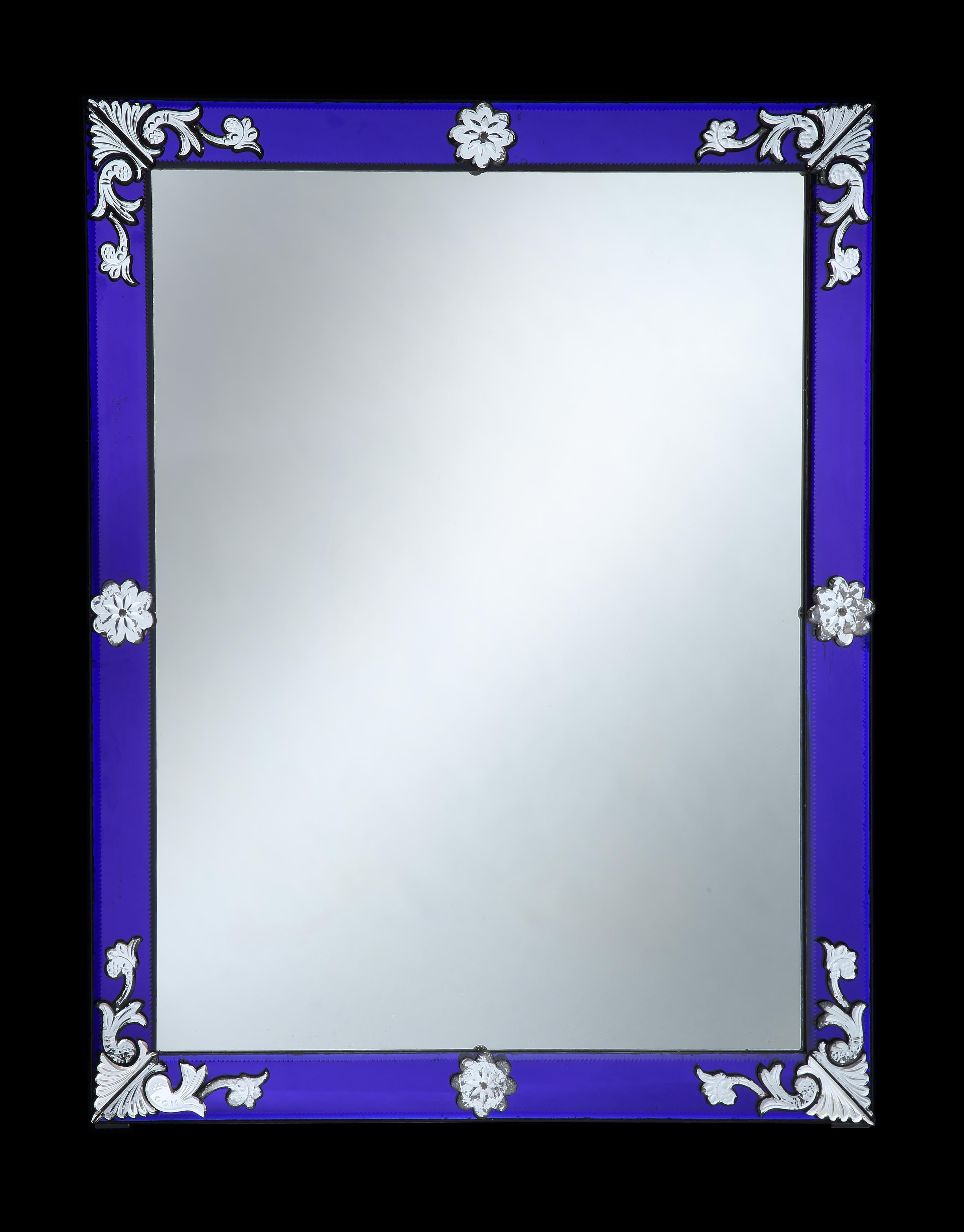 Italy, circa 1890

An exceptional late 19th century Venetian mirror of large scale, with striking cobalt blue glass borders and foliate designs of flowers and paterae to the corners and marginal plates, retaining the original mercury mirror