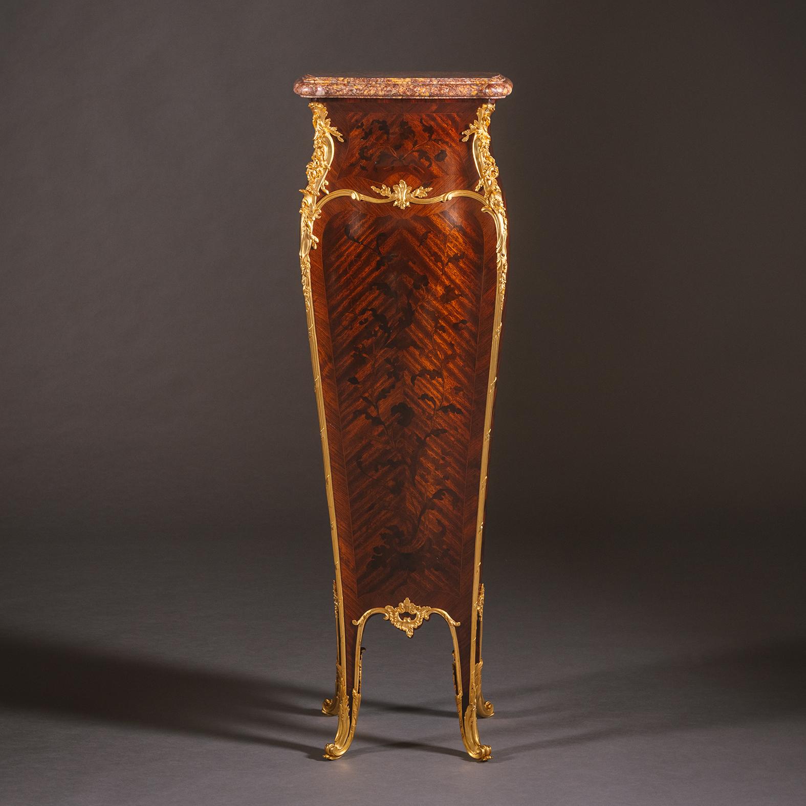 Un raffinato piedistallo in intarsio montato in bronzo dorato in stile Luigi XV, con piano in marmo, di François Linke, Parigi. 

Il piano sagomato in marmo di Boi Violette d'Espagne sovrasta una cassa a serpentina dotata di montature angolari