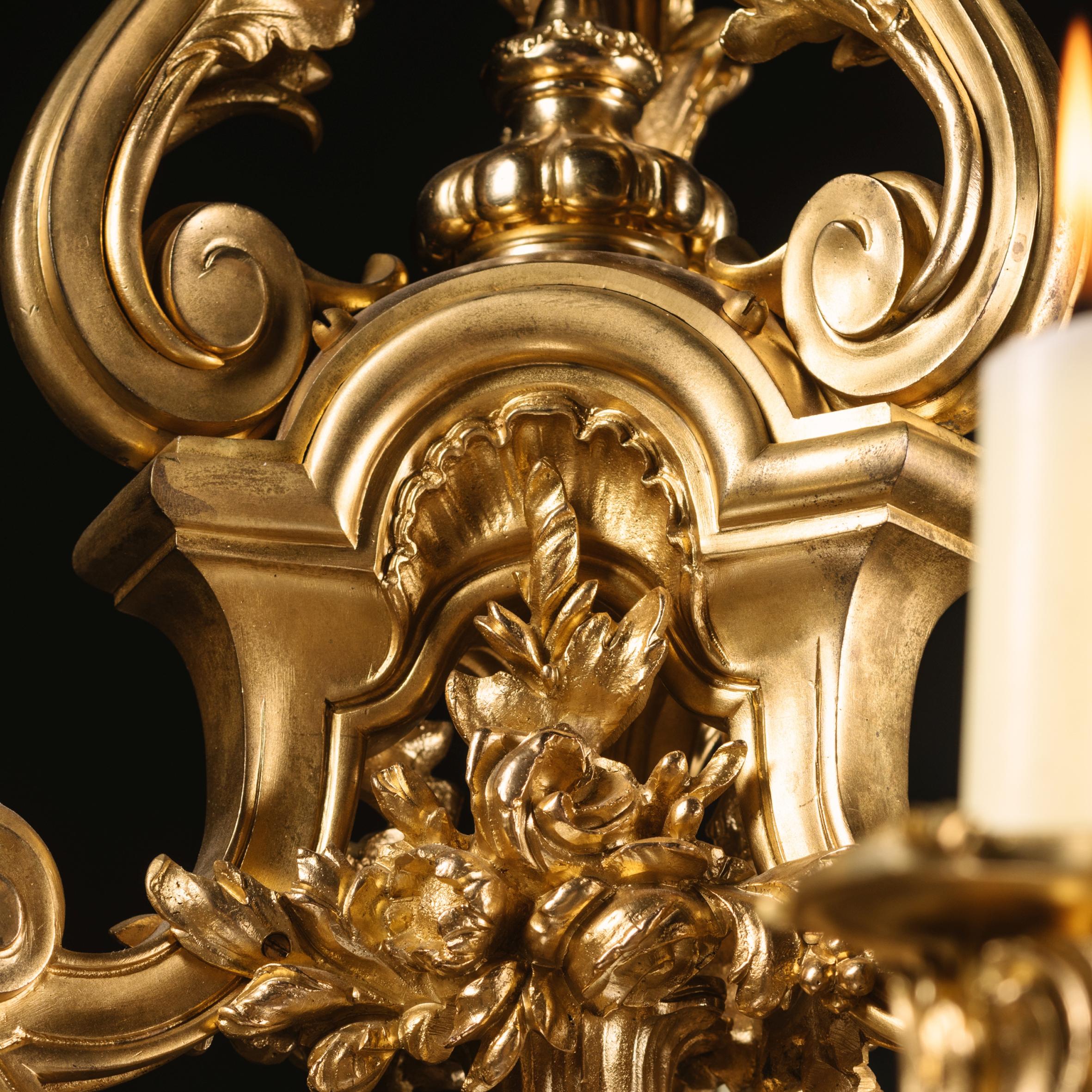 A fine Louis XV style gilt-bronze nine-light chandelier.

This impressive gilt-bronze tripartite baluster form cage chandelier is cast with a central vase issuing flowers and nine scrolling acanthus branches, terminating in foliate sconces.