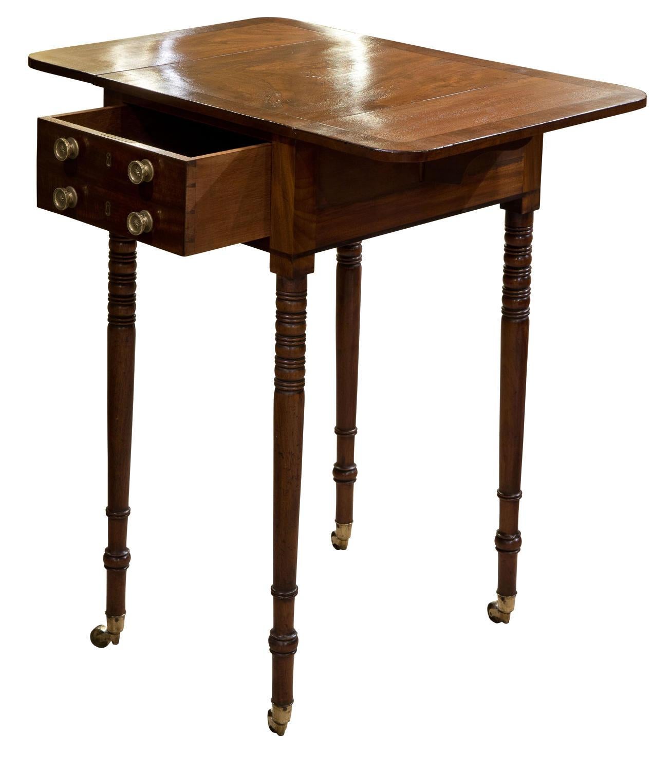 A fine mahogany worktable with cross banded dropleaf top and single drawer under. Standing on fine turned legs with brass castors

Depth with leaves down 35cm

c1810
