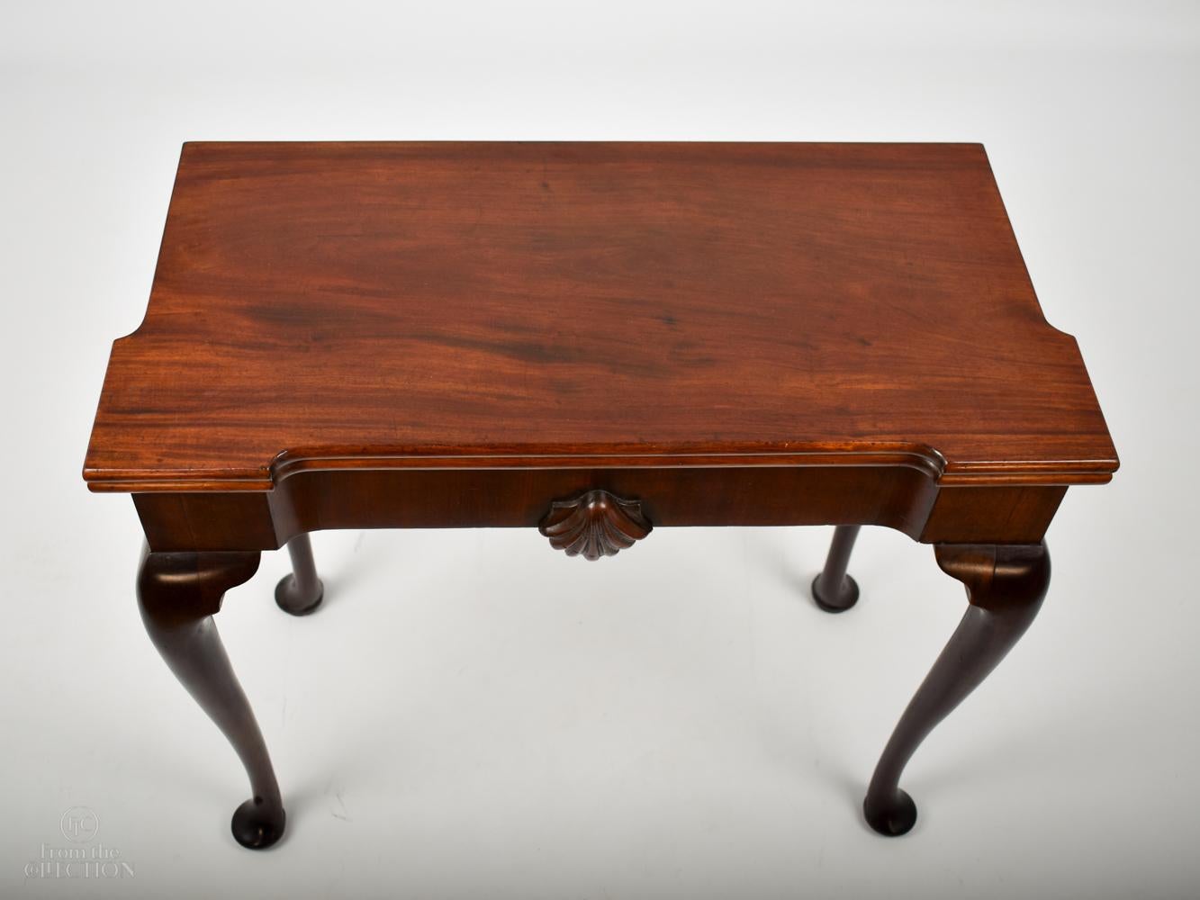 A fine mahogany Irish games table circa. 1770. This table folds out on a concertina leg mechanism to a green baize top with four counter wells and four square candle or glass holders. The table top sits on four cabriole legs with pad feet. In