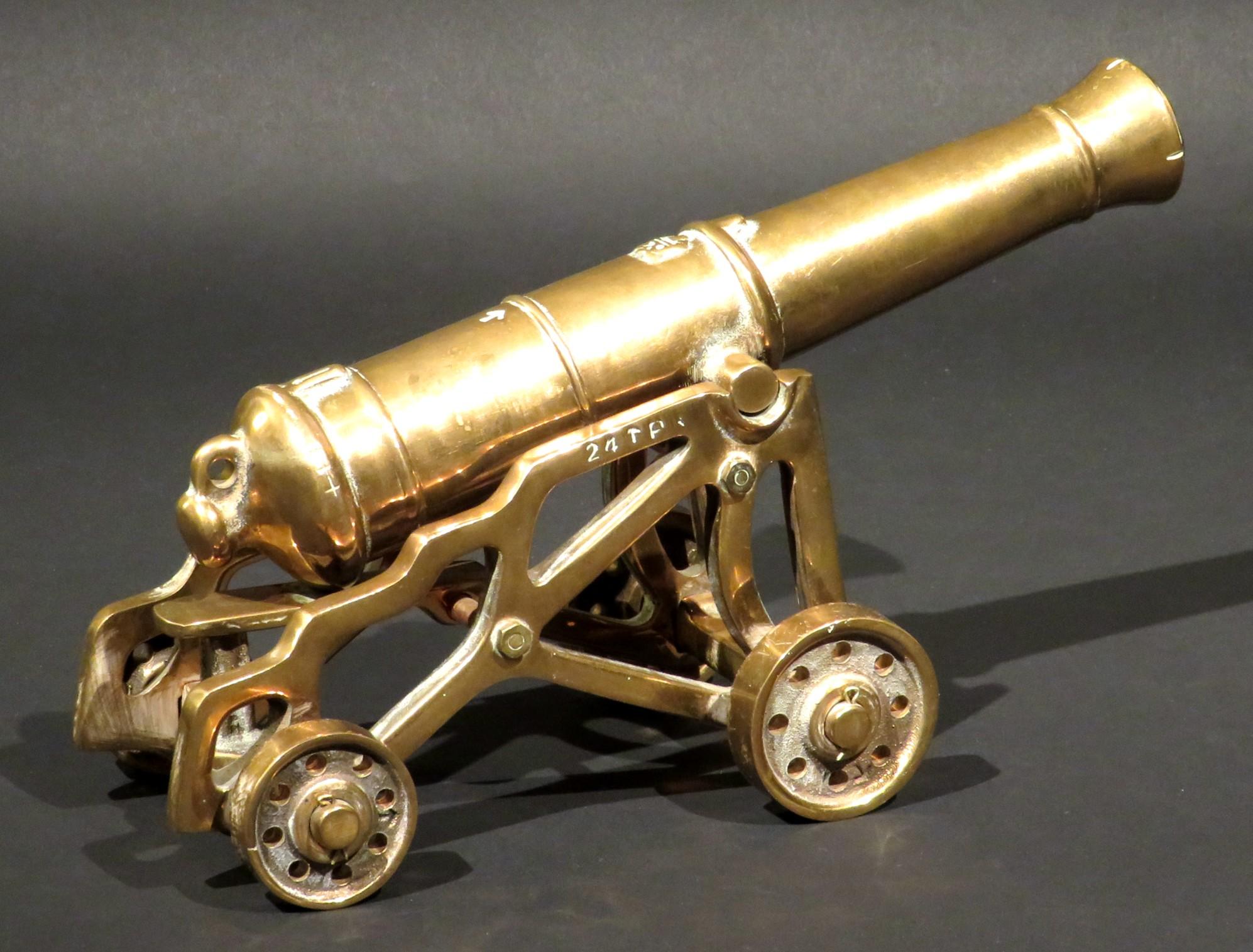 A finely cast model of an early 19th century British 24-pounder smoothbore muzzle-loading artillery cannon, together with its garrison style carriage. 
Both cast in heavy gauge 'bell metal', the gun is accurately represented with the Royal Cypher of