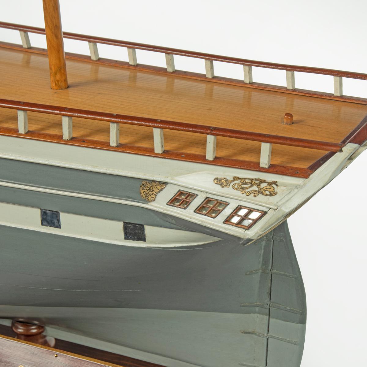 This wooden model is painted in both light and dark grey with a white gunport band and faux gunports, a golden lion figurehead and the name Vimiera in applied gold lettering on the bow.  There are three masts, sparse deck fittings and mahogany