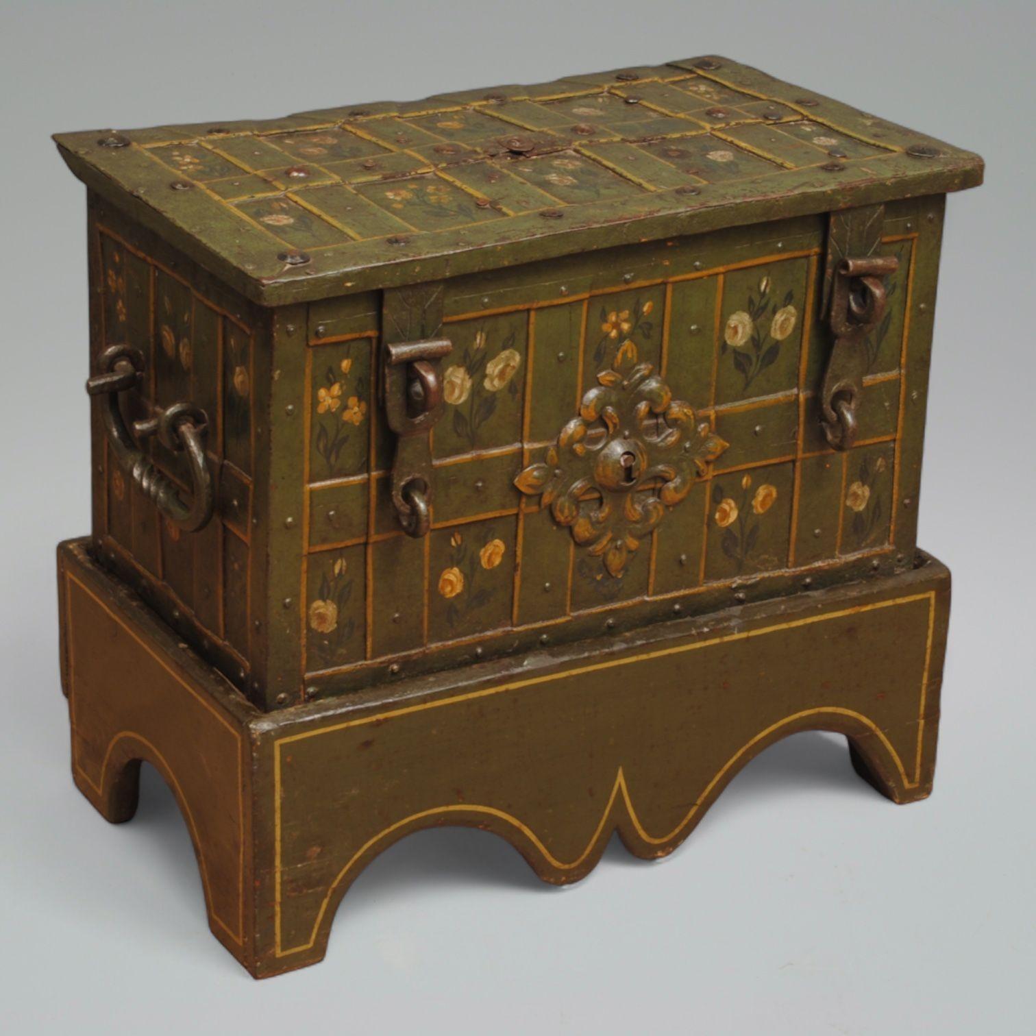 A 17th century painted Armada chest with a finely engraved steel lock plate with Maidens, flowers, and a brass central boss.
The outside is painted with a green background and floral panels, the fake central lock plate with gilded decoration and