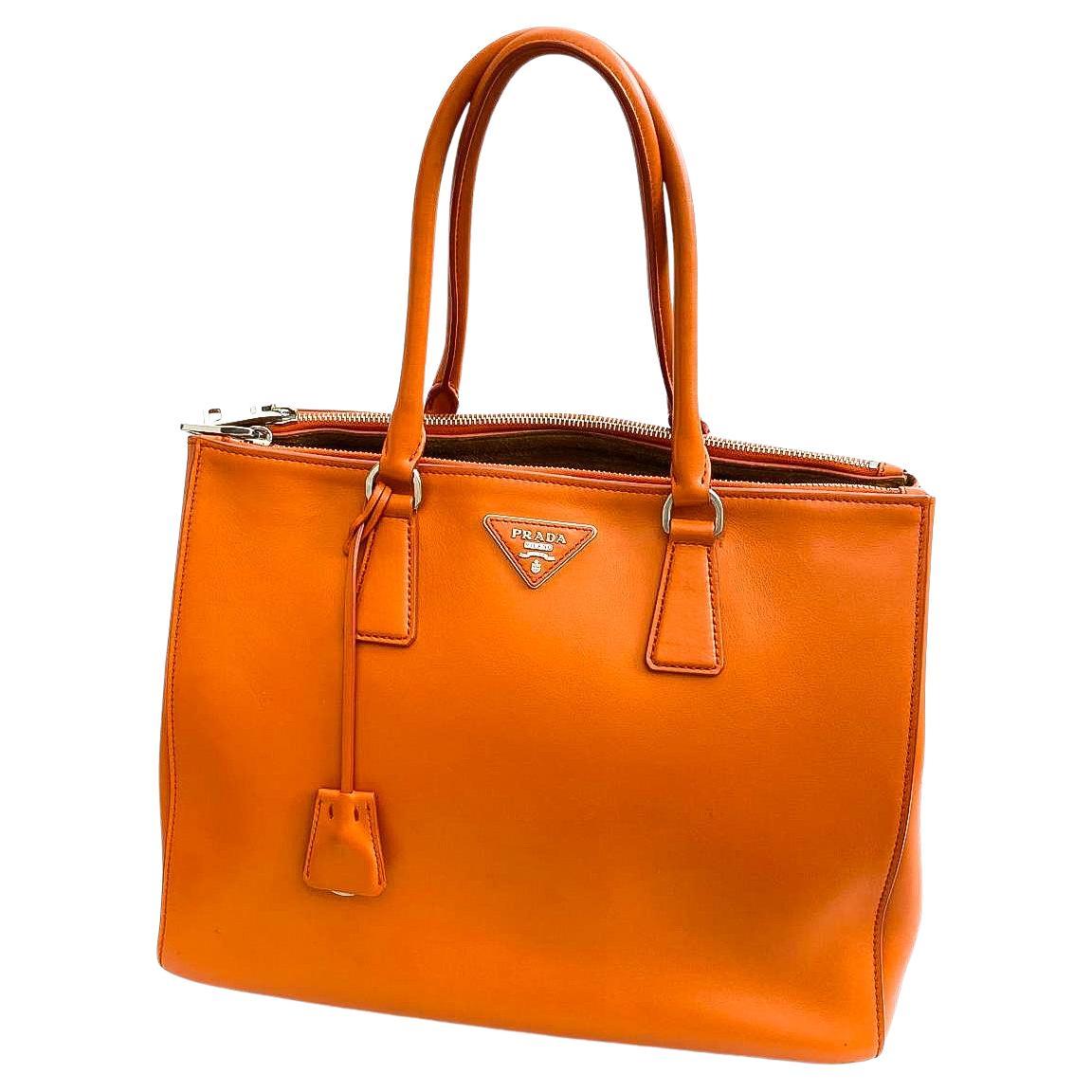 This classic Prada handbag, in a very lush orange calf leather, is known as the iconic 'Galleria' model. The highest craftsmanship and care has been employed in the making and design of this classic accessory. Tailor made for the 21st century, this