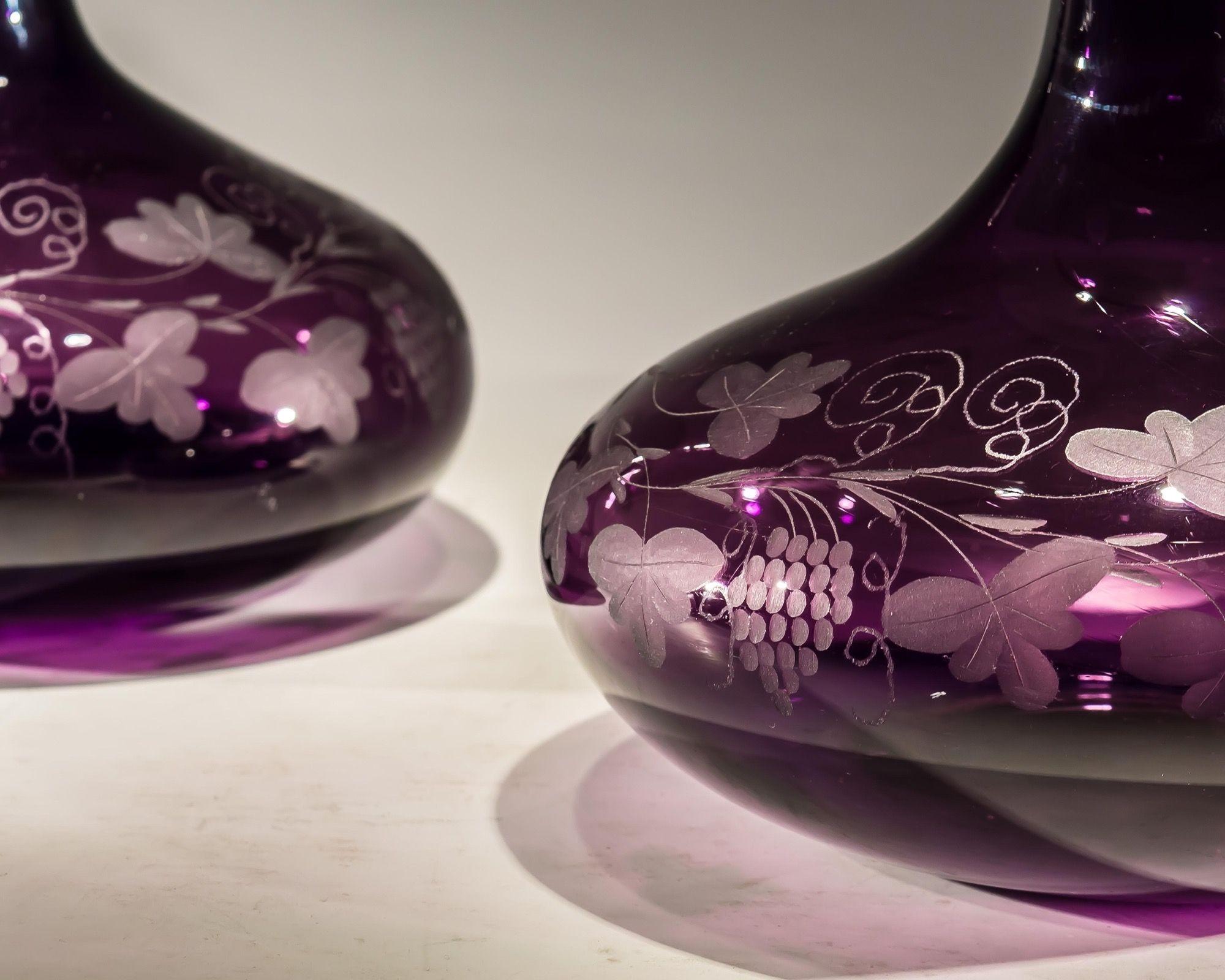 A fine pair of Amethyst decanters engraved with fruiting vine fitted with silvered mounted mother of pearl, cork stoppers labelled Port & Sherry.