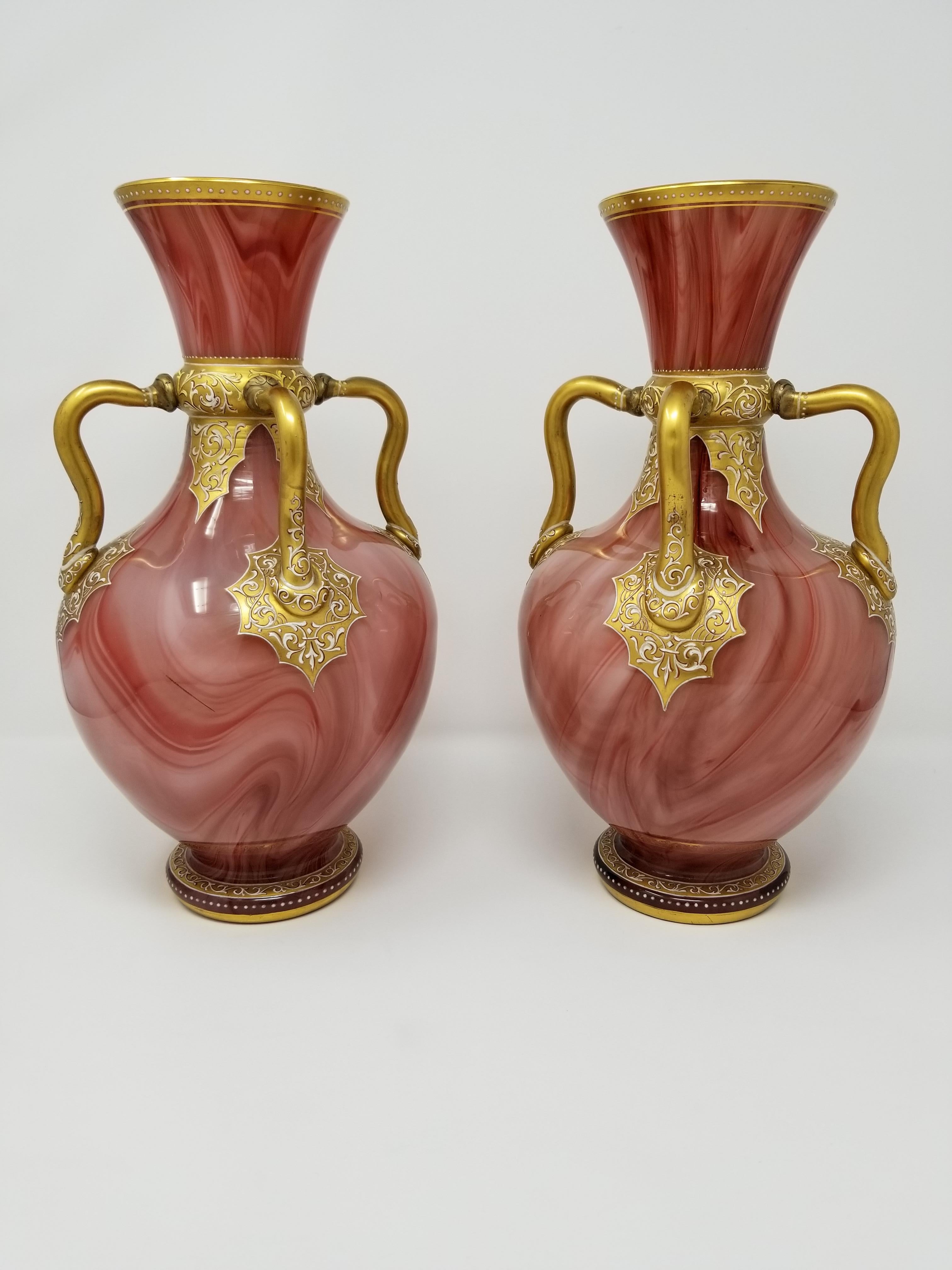 A fine pair of antique Orientalist Moser enameled marbleized glass vases in the Orientalist style. With an unusual pink/brick color with four hand-applied glass handles. Each decorated in the orientalist design with beautiful marbleized strokes of