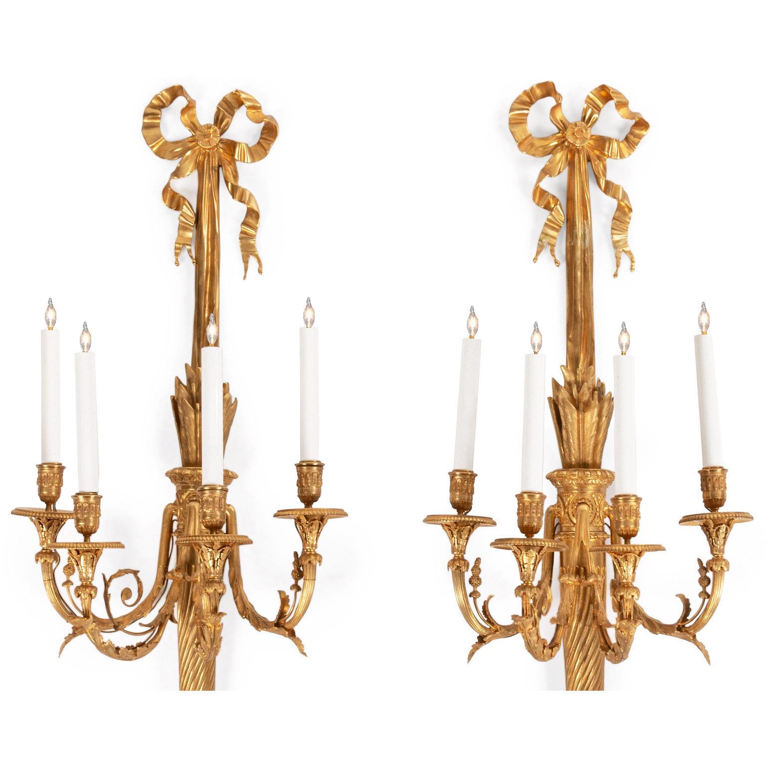 A fine pair of French 19th century Louis XVI style gilt bronze four-light wall sconces (Wall Lights). The back plate in the form of a torch with four scrolled candle arms protruding from the center frame, each decorated acanthus leaves and acorns
