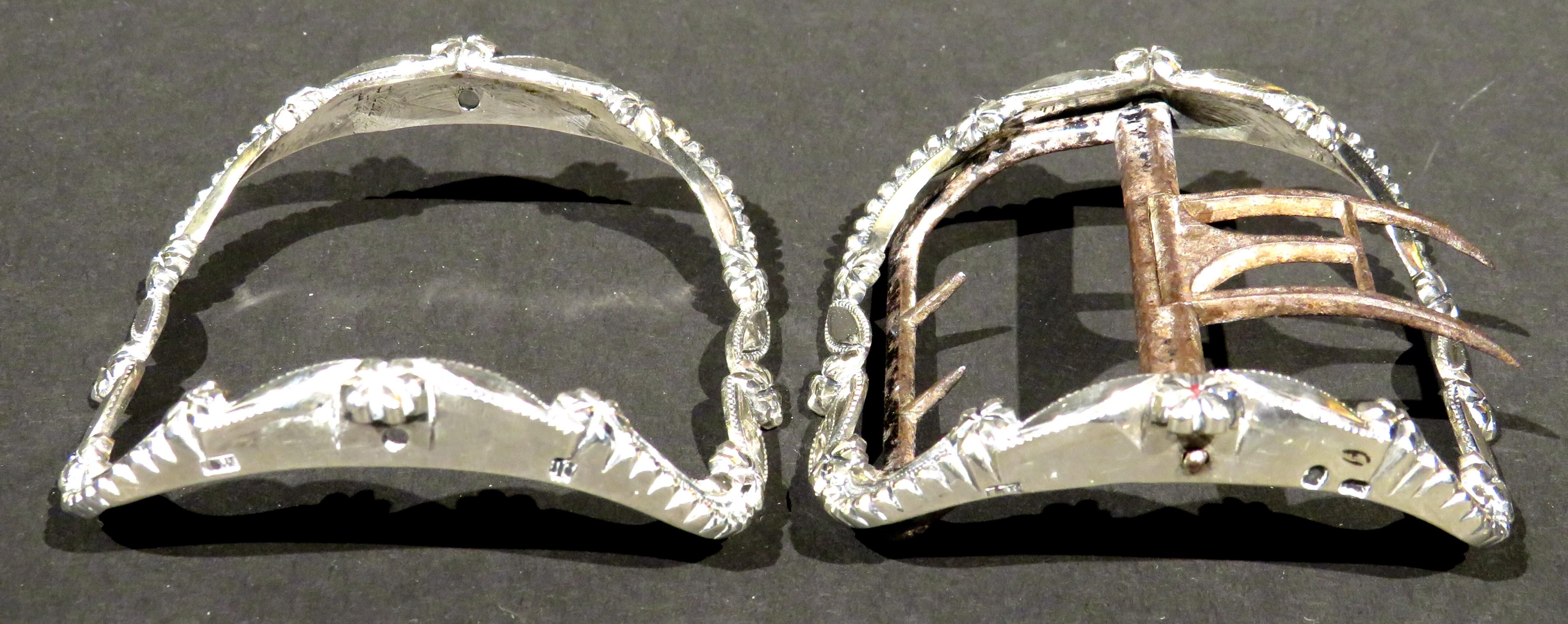 A fine pair of 18th century British sterling silver shoe buckles of exceptional quality. Both showing curvilinear shaped segments interspersed by flower-heads & leaf shaped elements, decorated with hand engraved bright-cut detail. 
Both buckles
