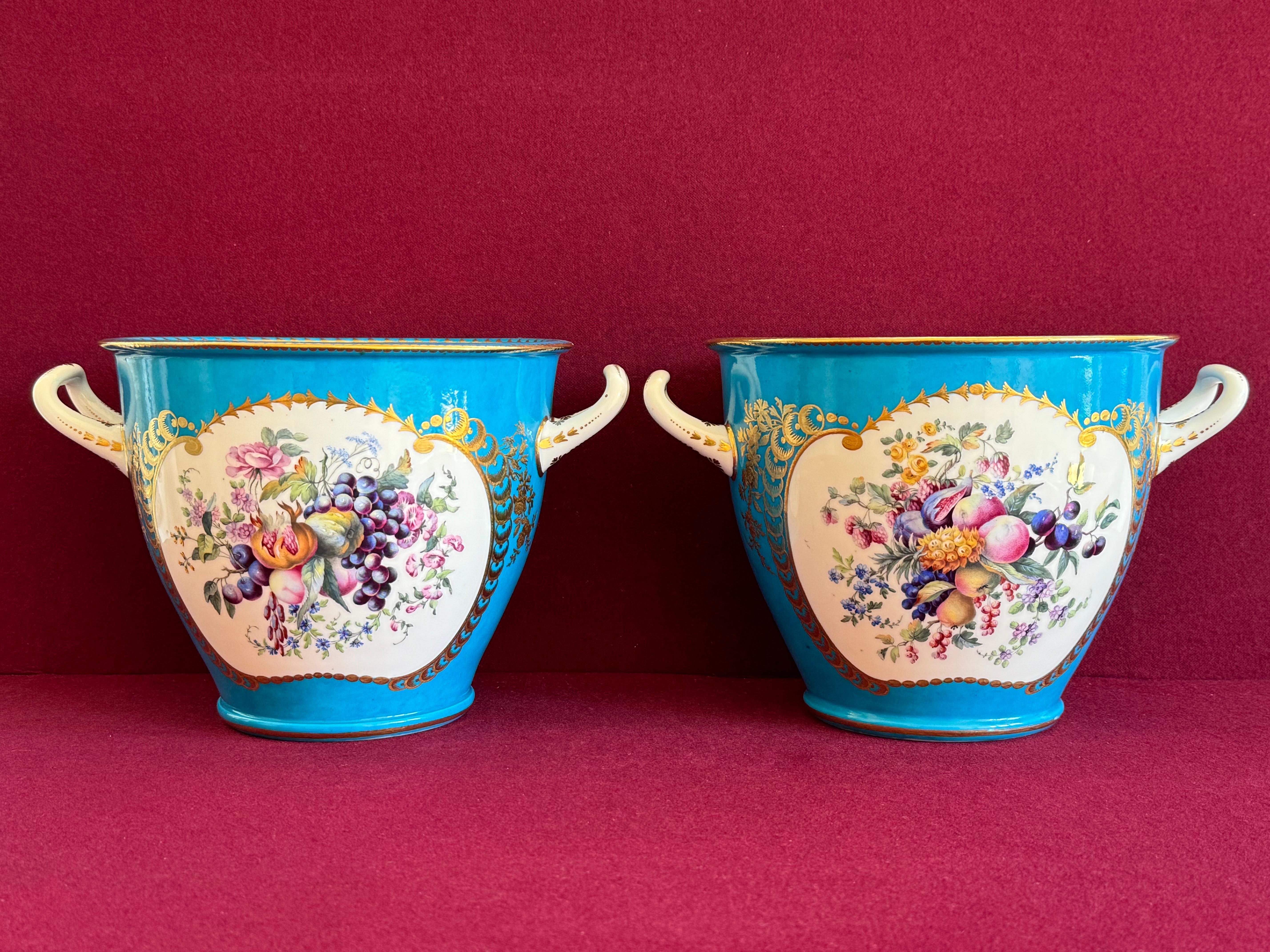 Fina pareja de enfriadores de botellas (Seaux à bouteille) de porcelana de pasta blanda de Sèvres del siglo XVIII. Las neveras de forma etrusca, cada una con dos asas de lazo, están finamente decoradas con un fondo azul turquesa (Bleu Céleste), muy