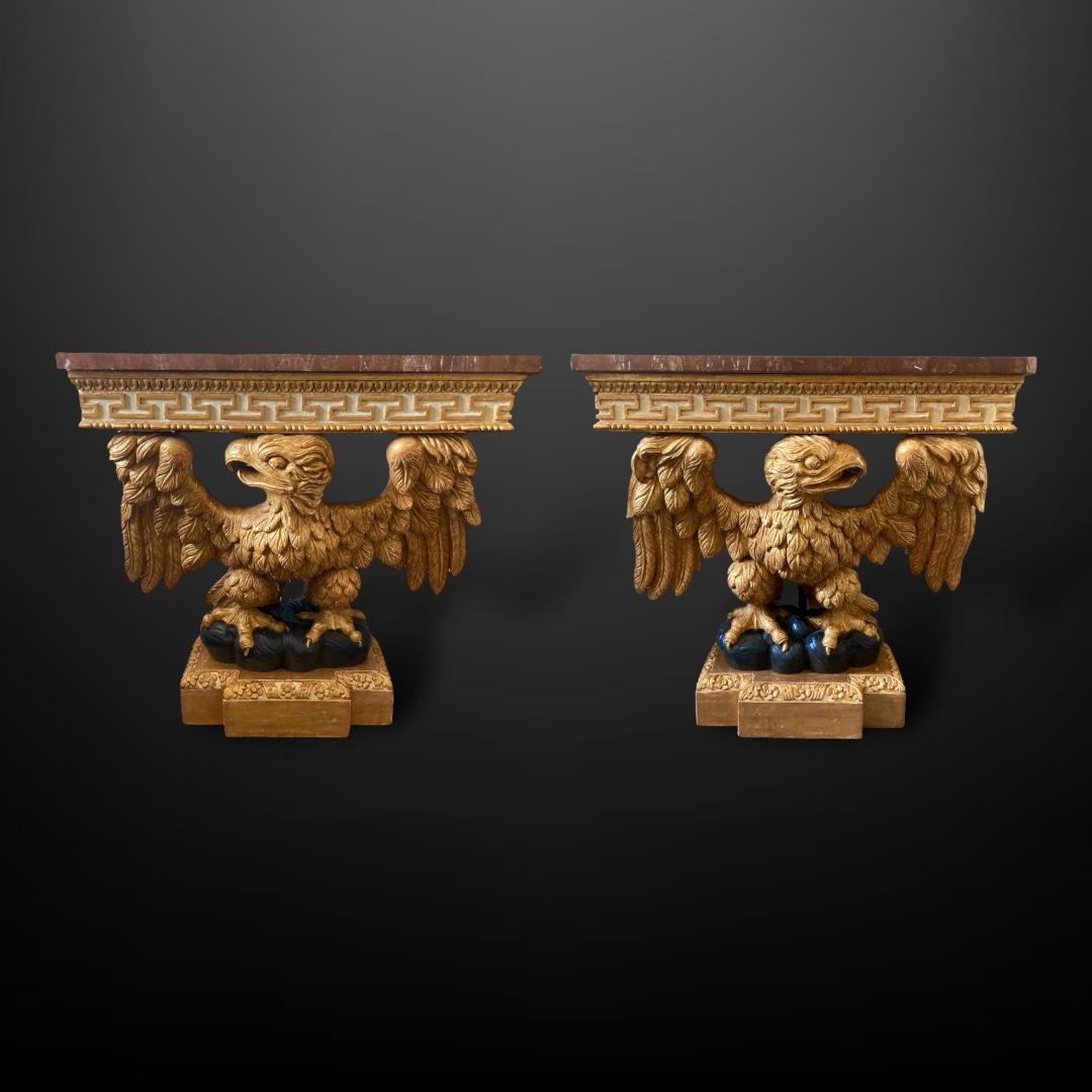 Ein Paar Konsolentische aus Adler-Gilberholz im Stil von George II des 20. Jeder Tisch hat eine reiche, warme Marmorplatte, die von einem Fries aus griechischem Giltwood gehalten wird.  Die beiden Adler mit ihren ausgebreiteten Flügeln spiegeln sich