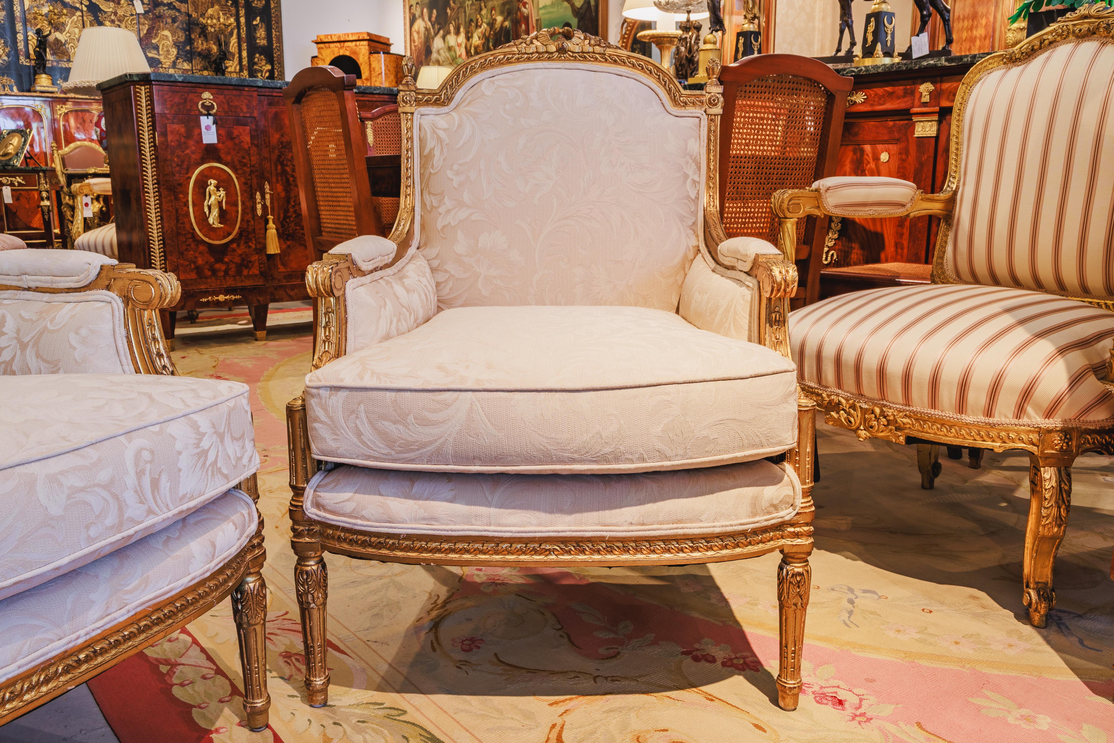A fine pair of late 19th century French Louis XVI giltwood carved bergeres .