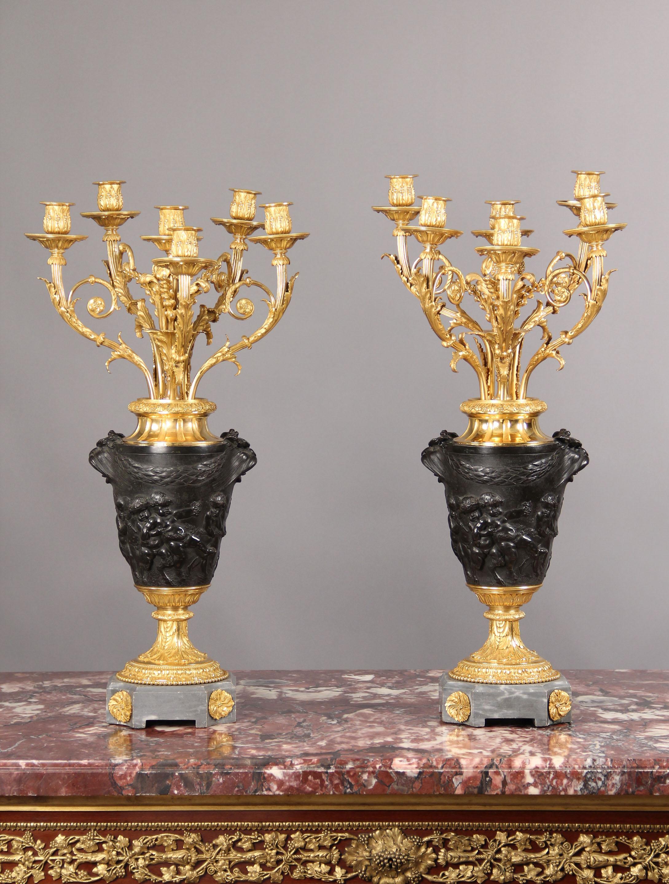 Paire de chandeliers à six lumières en bronze patiné et doré de la fin du XIXe siècle

D'après Claude-Michel Clodion

Chaque vase de forme effilée est orné de deux masques grotesques suspendus à des guirlandes de laurier, au-dessus d'une frise en