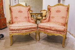 A fine pair of 19th century French  Louis XVI  gilt carved large wing chairs