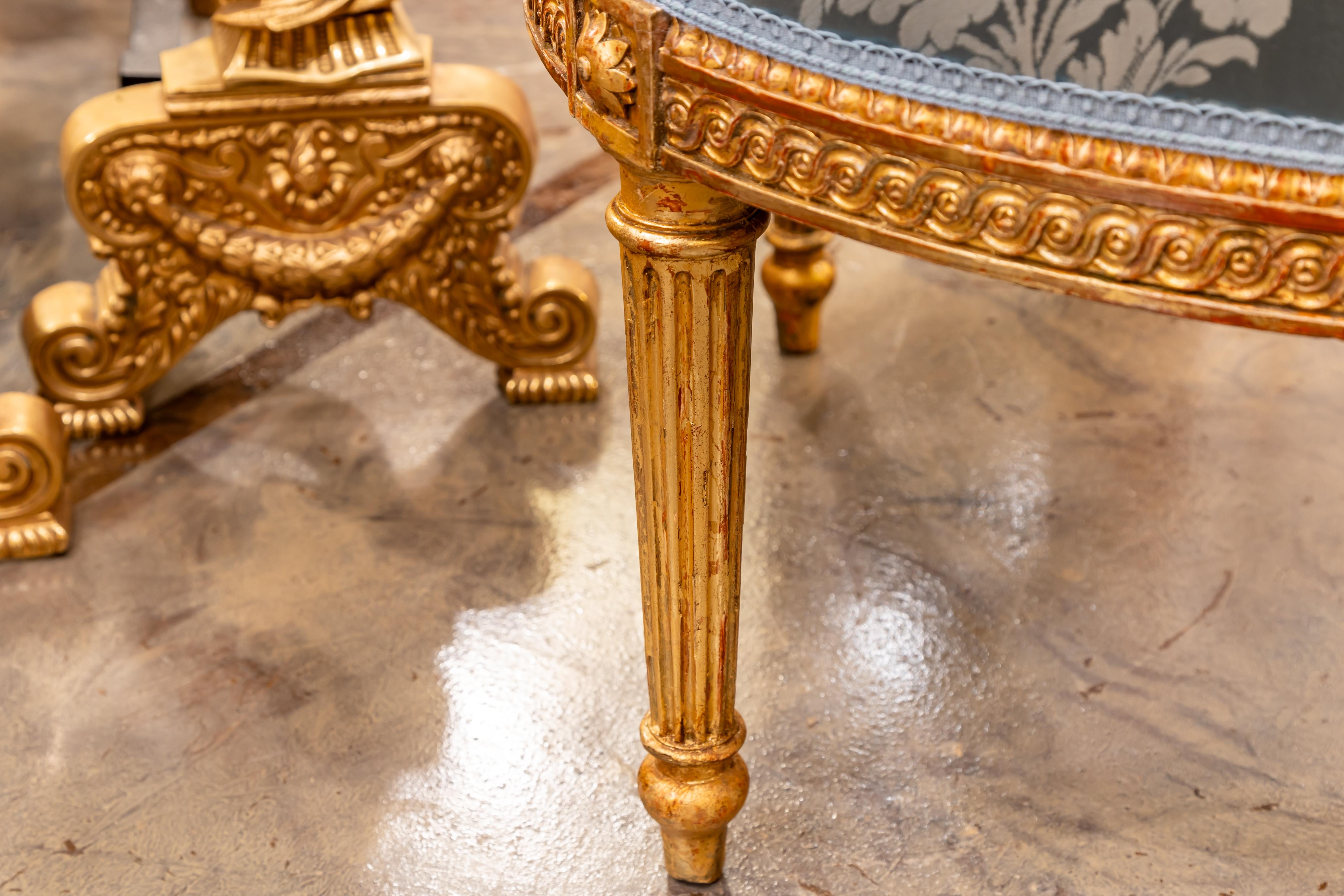 A fine pair of 19th century French Louis XVI hand carved and gilt armchairs. Covered in a blue silk with French gimp .