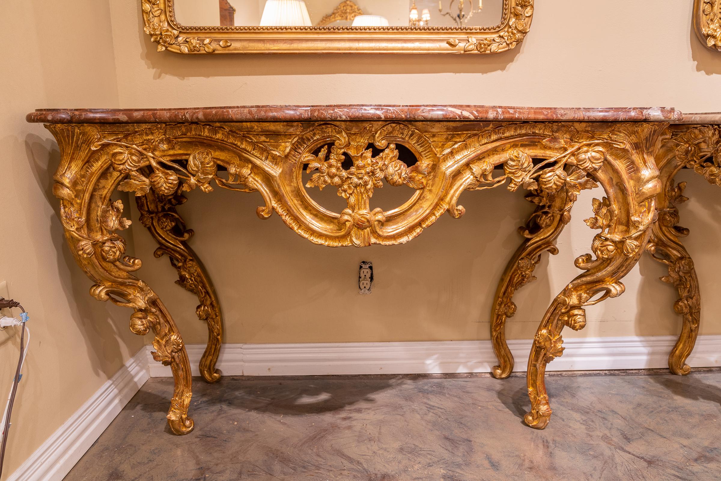 A fine pair of 19th century Italian Louis XV gilt carved marble topped consoles.
